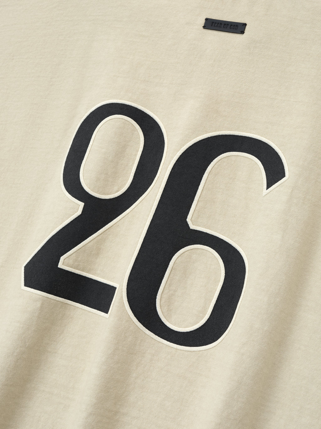 close-up of sun-faded beige heavyweight cotton tee with large black number 26 printed on front chest