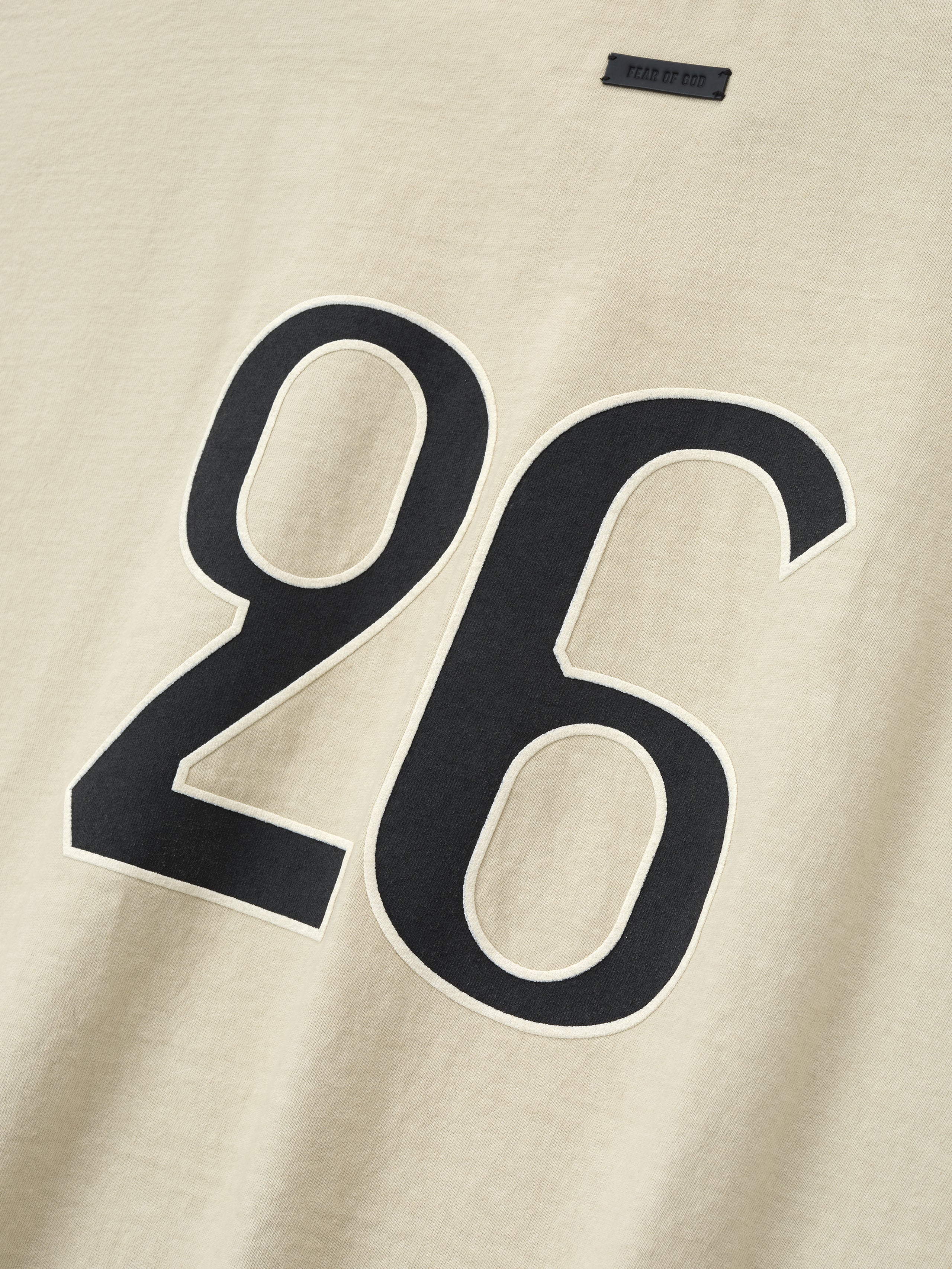 close-up of sun-faded beige heavyweight cotton tee with large black number 26 printed on front chest