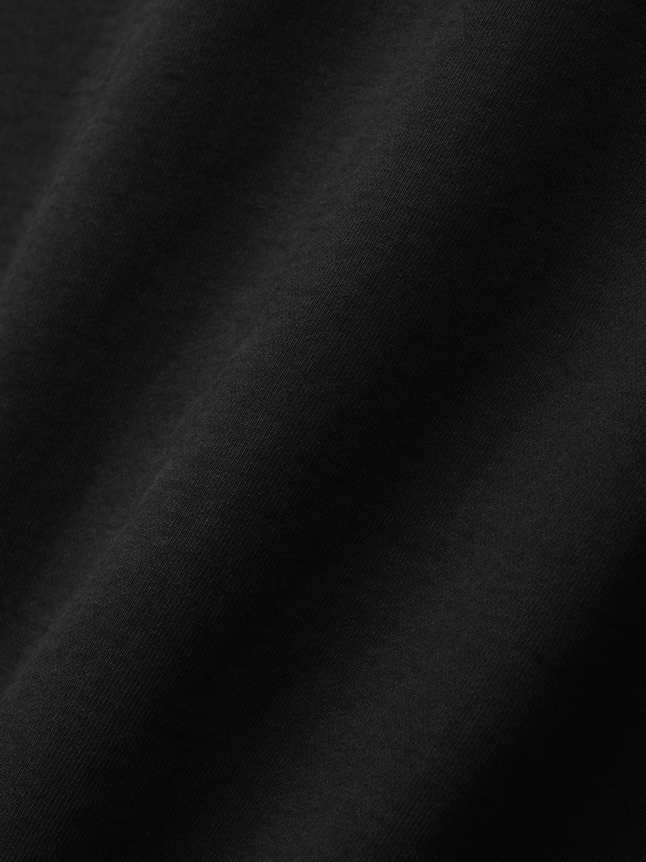 close-up of soft black heavyweight cotton fleece fabric with smooth texture and subtle natural folds