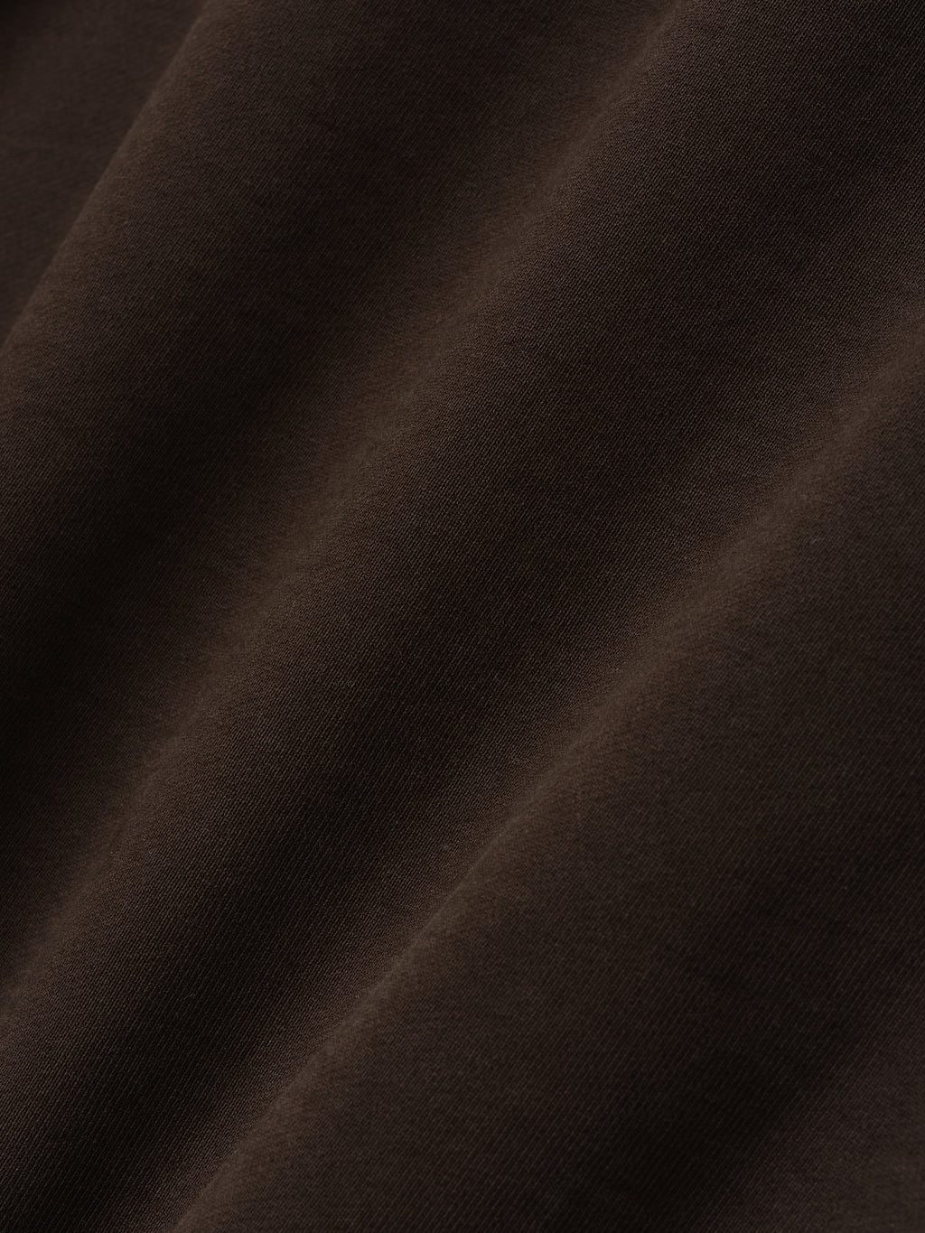 close-up of dark brown heavyweight cotton fleece fabric with soft texture and natural folds