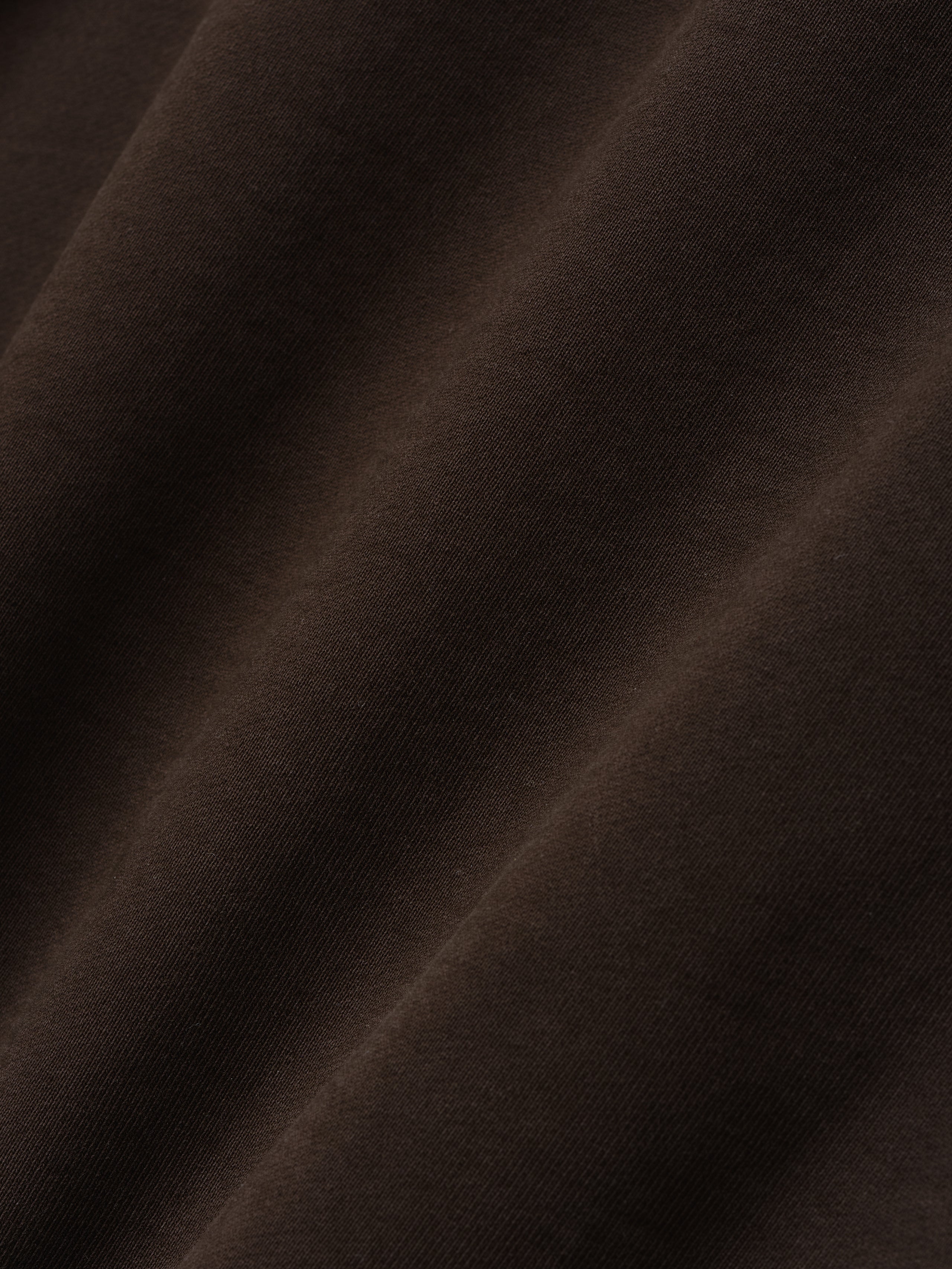 close-up of dark brown heavyweight cotton fleece fabric with soft texture and natural folds