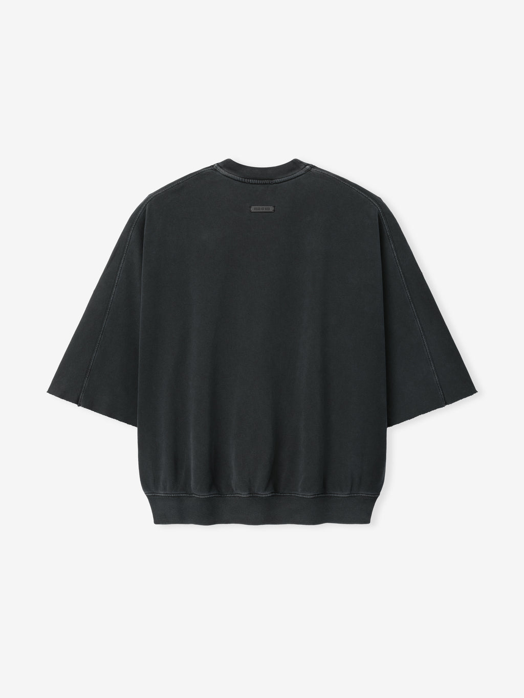 Back view of a black oversized sweatshirt with wide sleeves and a small rectangular label near the neckline