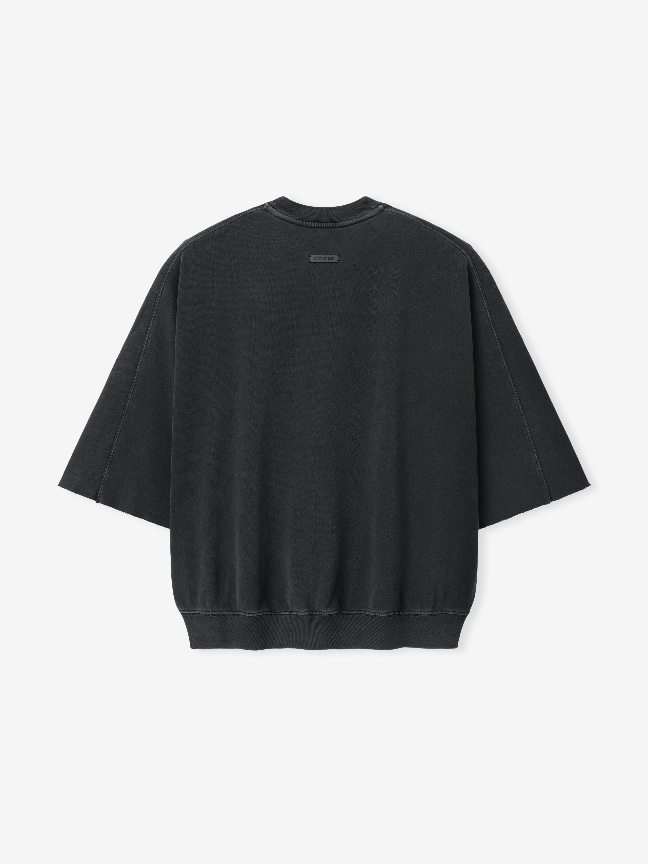 Back view of a black oversized sweatshirt with wide sleeves and a small rectangular label near the neckline