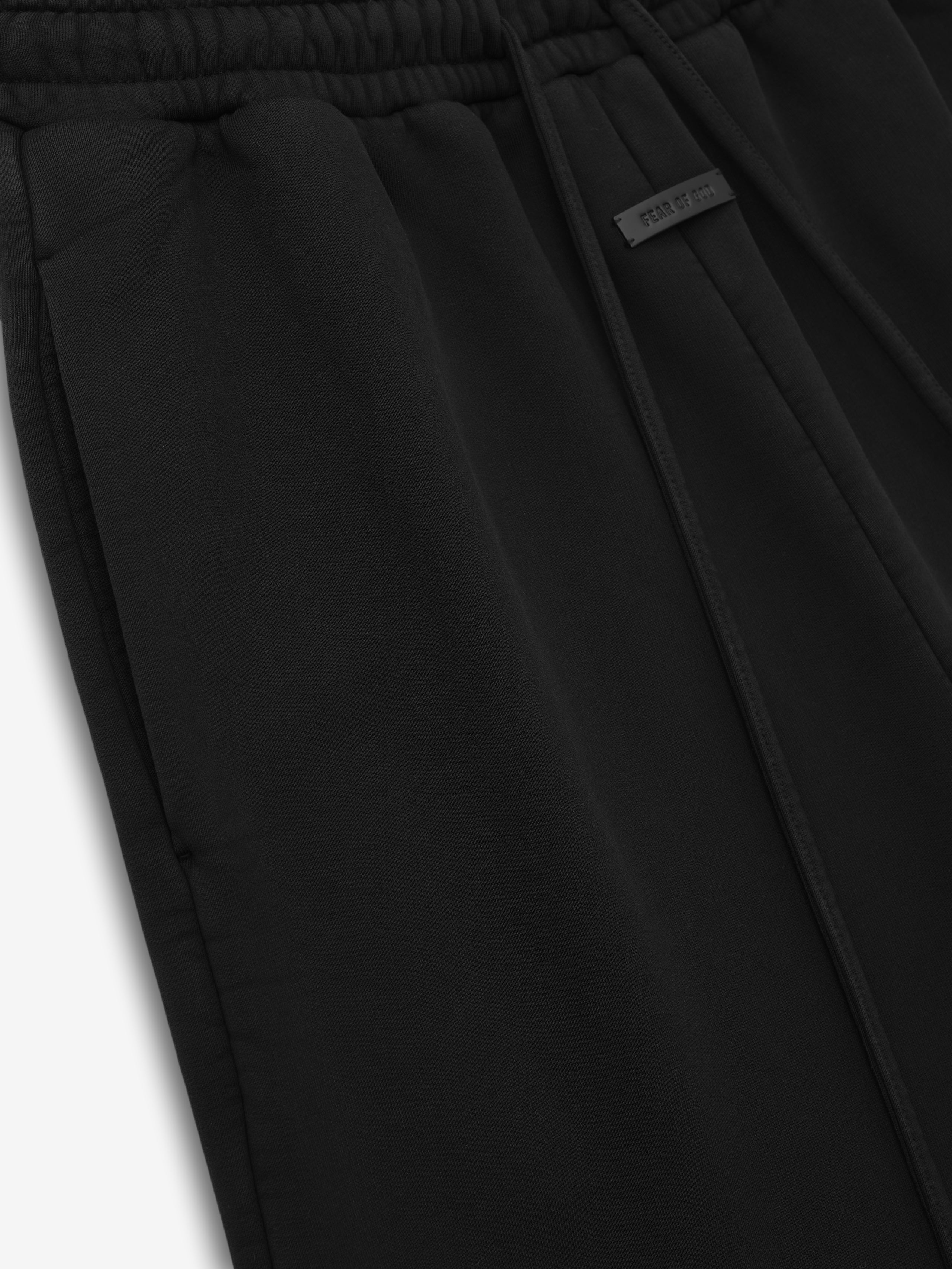 close-up of black wide leg cotton fleece sweatpants with elastic waistband, drawstring, and side pocket detail