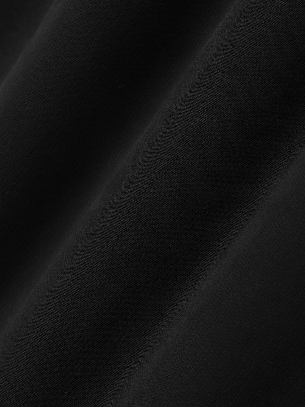 close-up of smooth black cotton fleece fabric with subtle texture and soft, matte finish on wide leg sweatpants