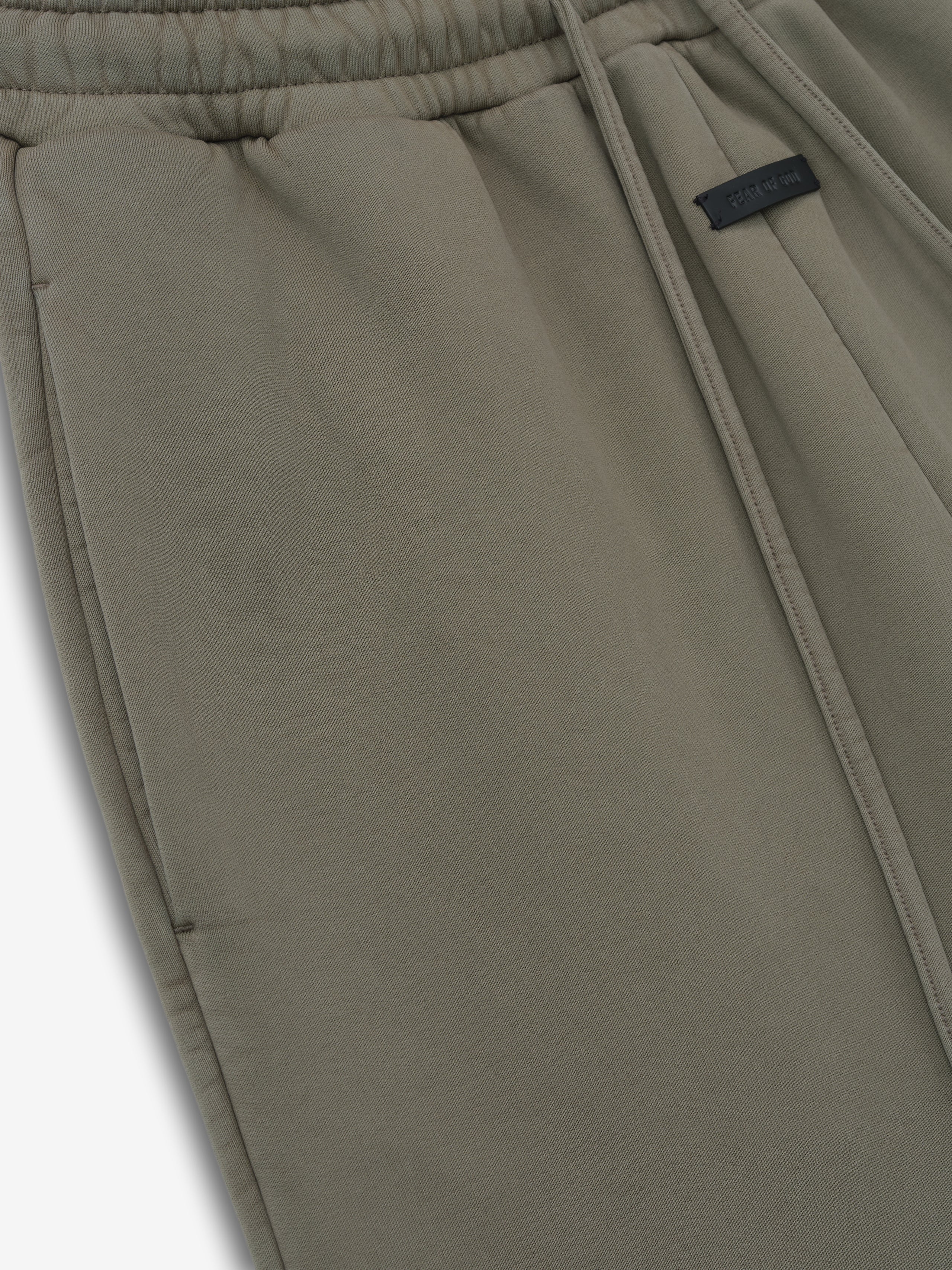 close-up of olive green cotton fleece wide leg sweatpants with elastic waistband, drawstring, and side pocket detail