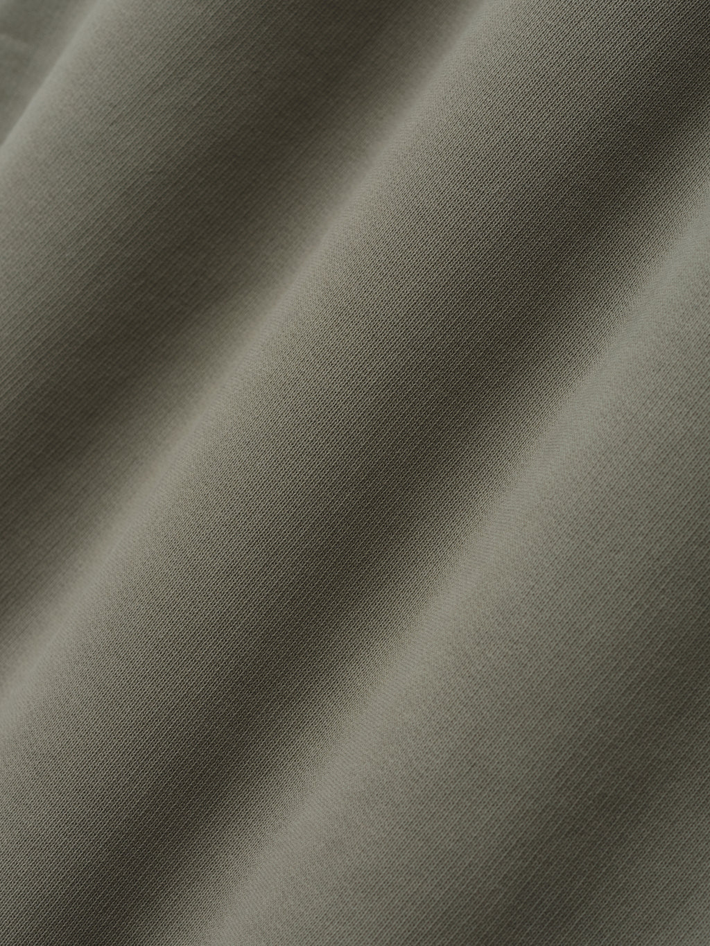 close-up of soft olive green cotton fleece fabric with smooth texture used in wide leg sweatpants