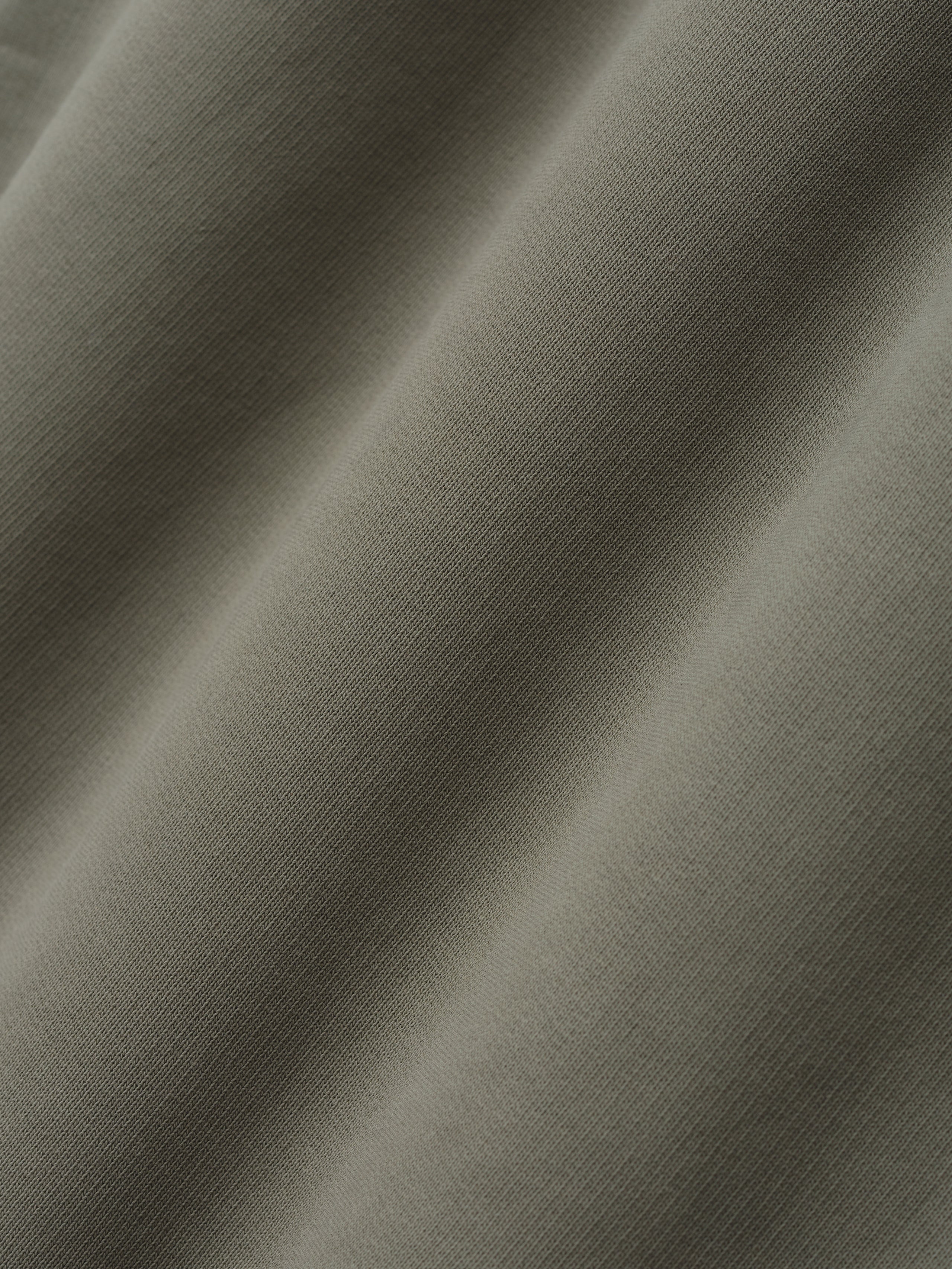 close-up of soft olive green cotton fleece fabric with smooth texture used in wide leg sweatpants