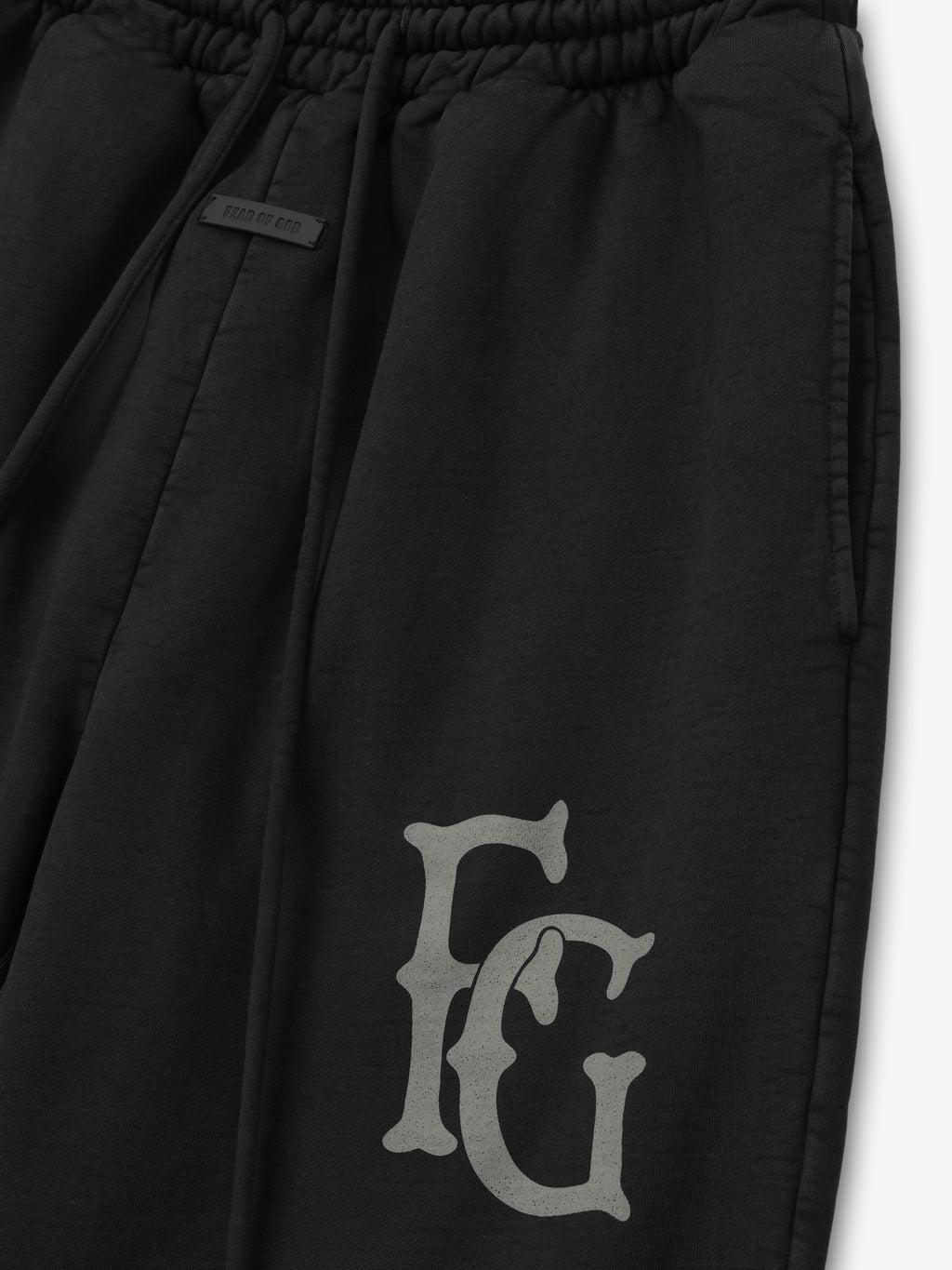 black heavyweight cotton fleece sweatpants with elastic waistband and large hand-printed FG logo on left leg