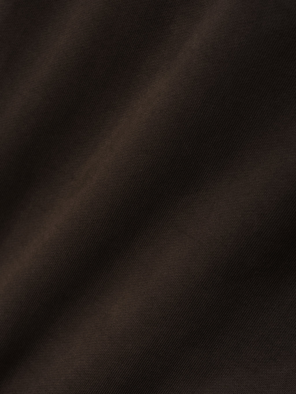 Close-up of dark brown fabric with a soft, smooth texture and subtle diagonal weave pattern