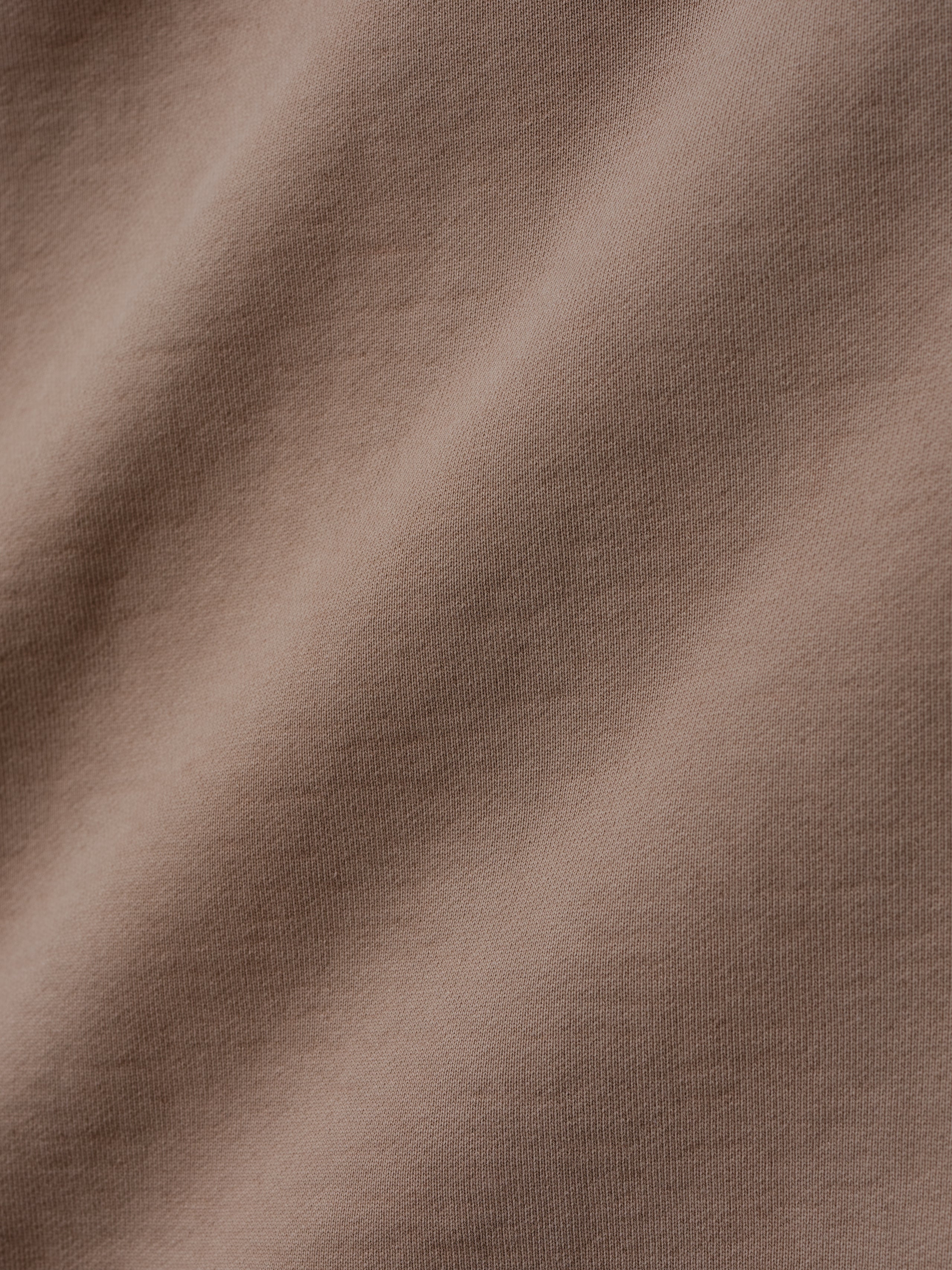 close-up of taupe heavyweight cotton fleece fabric with soft texture and subtle garment-washed vintage finish