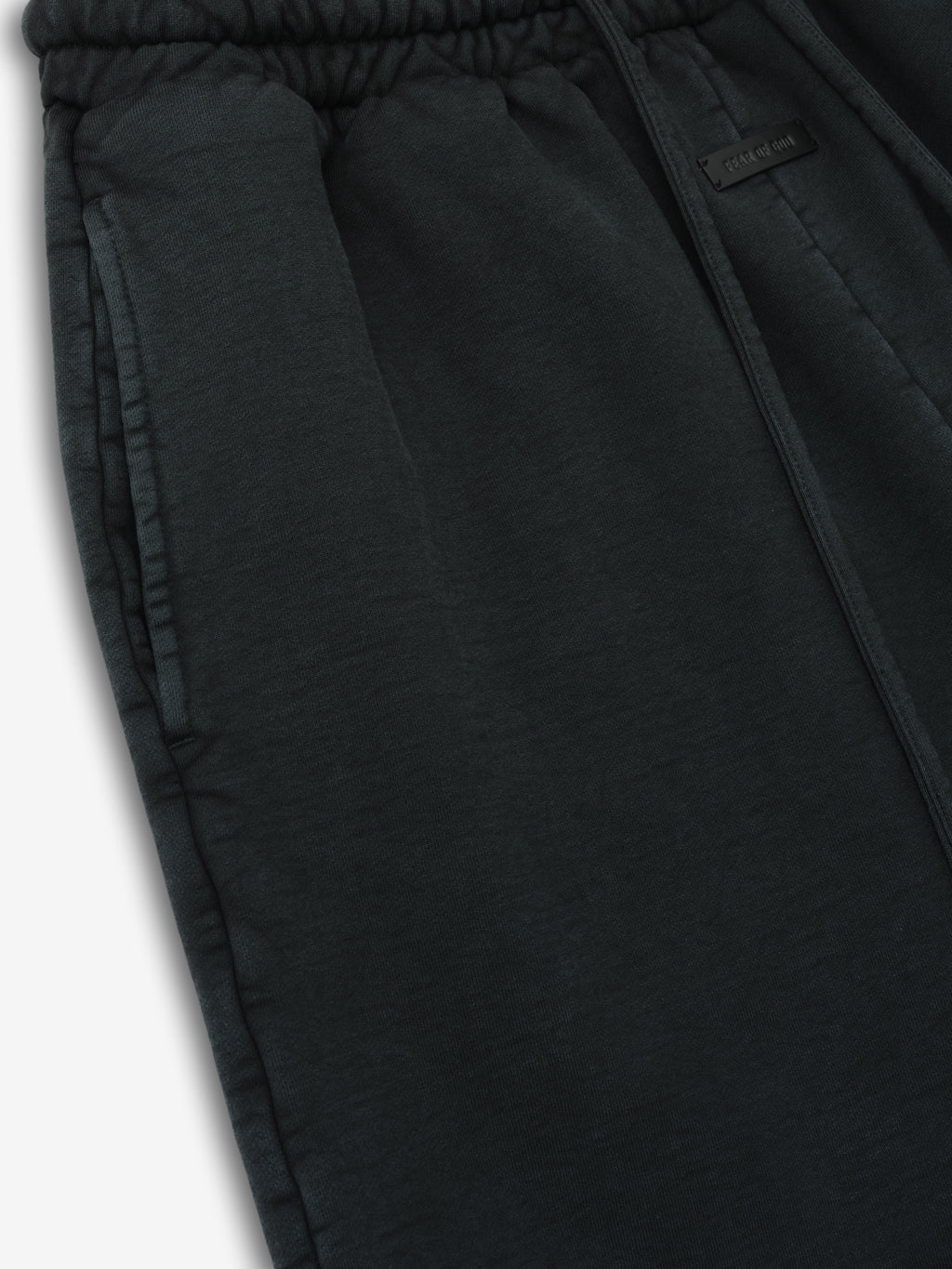 close-up of black garment-dyed heavy cotton fleece sweatshorts with elastic drawstring waistband and side pockets