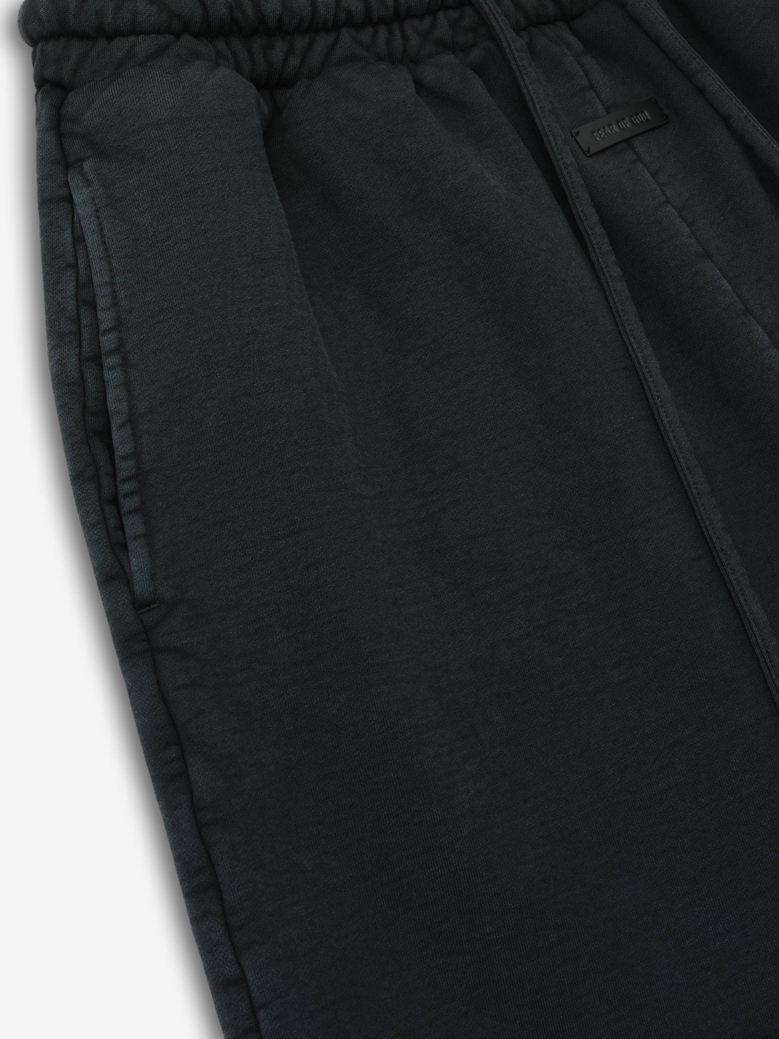 close-up of black garment-dyed heavy cotton fleece sweatshorts with elastic drawstring waistband and side pockets