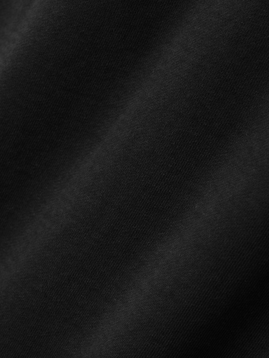 close-up of black heavyweight cotton fleece fabric with a soft texture and subtle sunfaded vintage wash finish