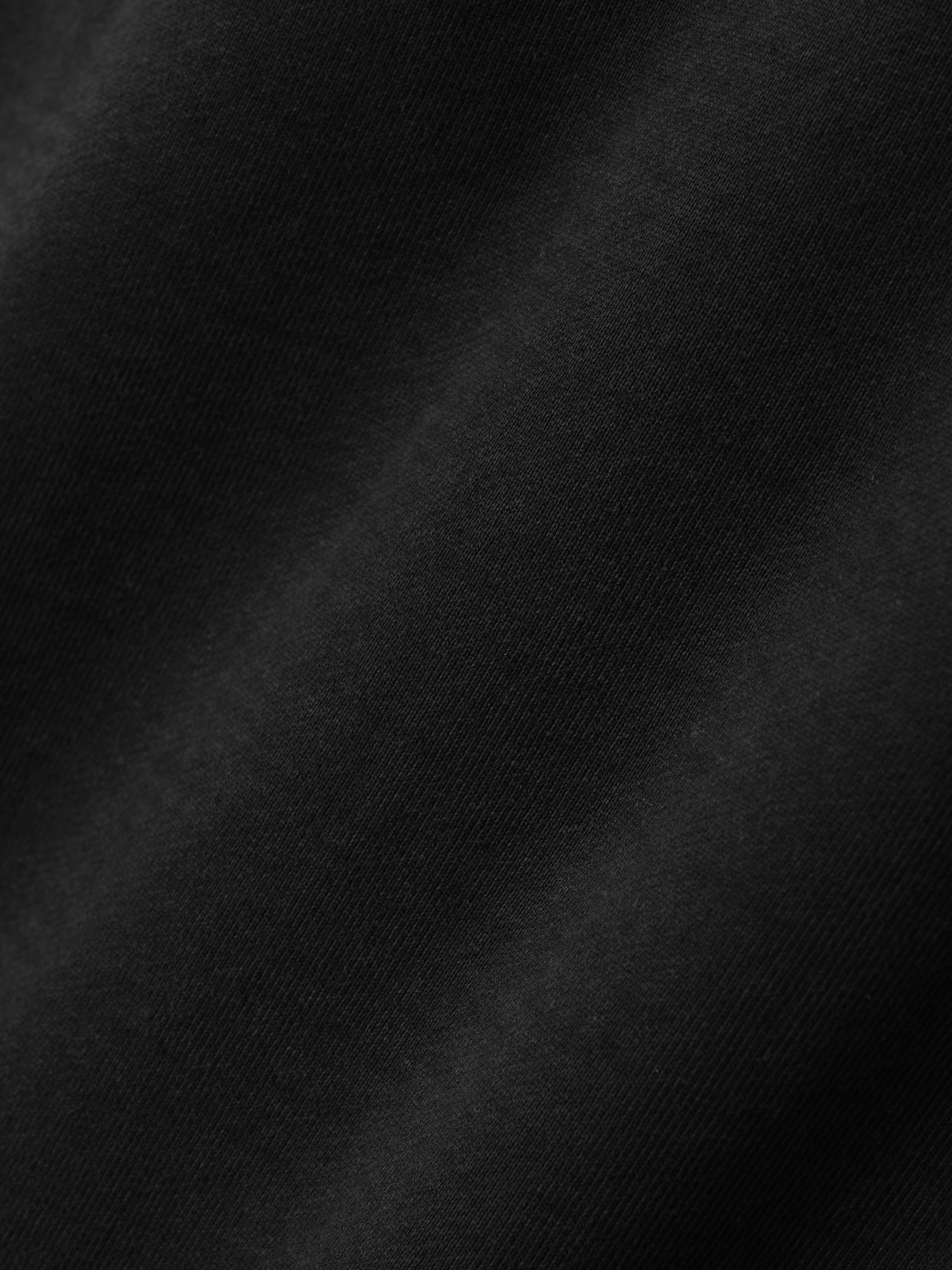 close-up of black heavyweight cotton fleece fabric with a soft texture and subtle sunfaded vintage wash finish
