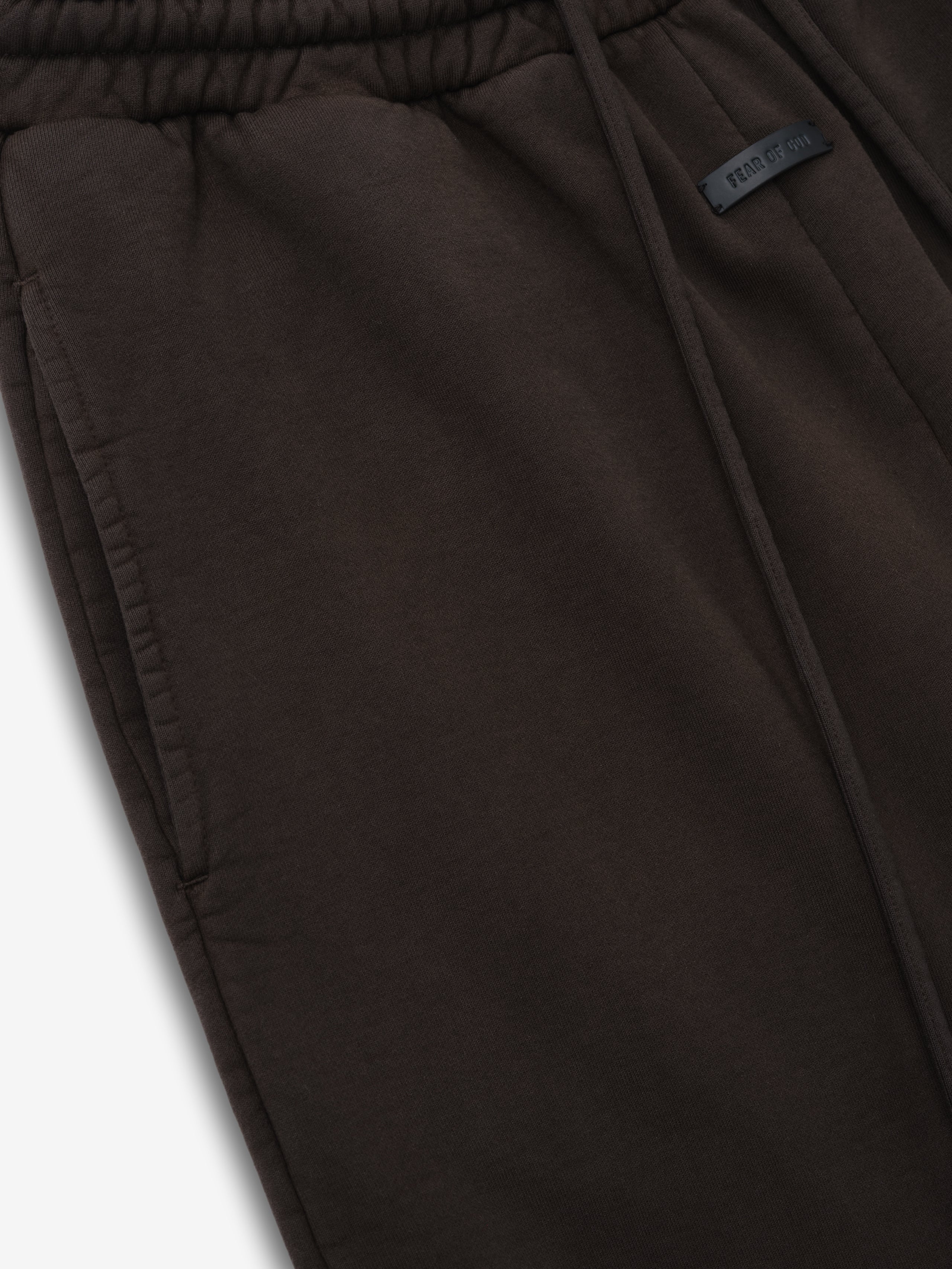 close-up of dark brown heavyweight cotton fleece sweatpant with elastic waistband and side pocket detailing