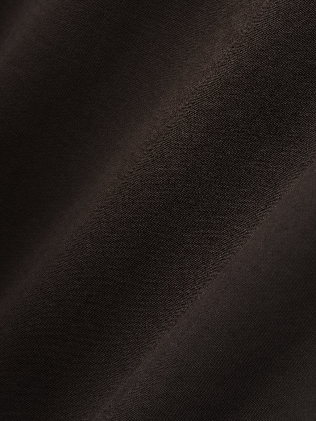 close-up of dark brown heavyweight cotton fleece fabric with soft texture and subtle sunfade garment wash finish
