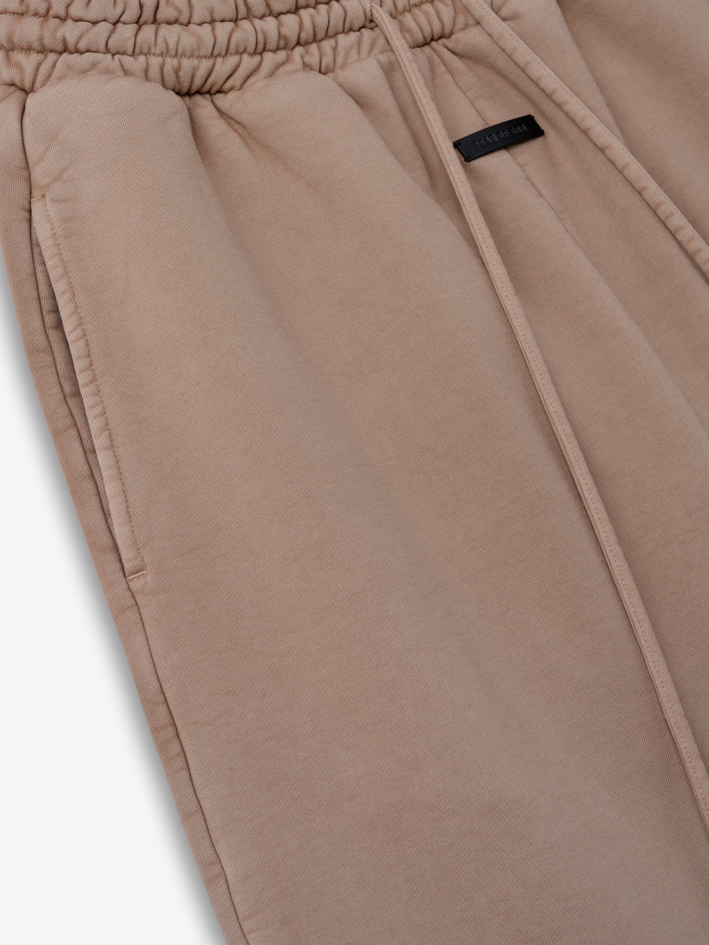 close-up of sunfaded beige heavyweight cotton fleece sweatpant with elastic waistband and side seam pocket