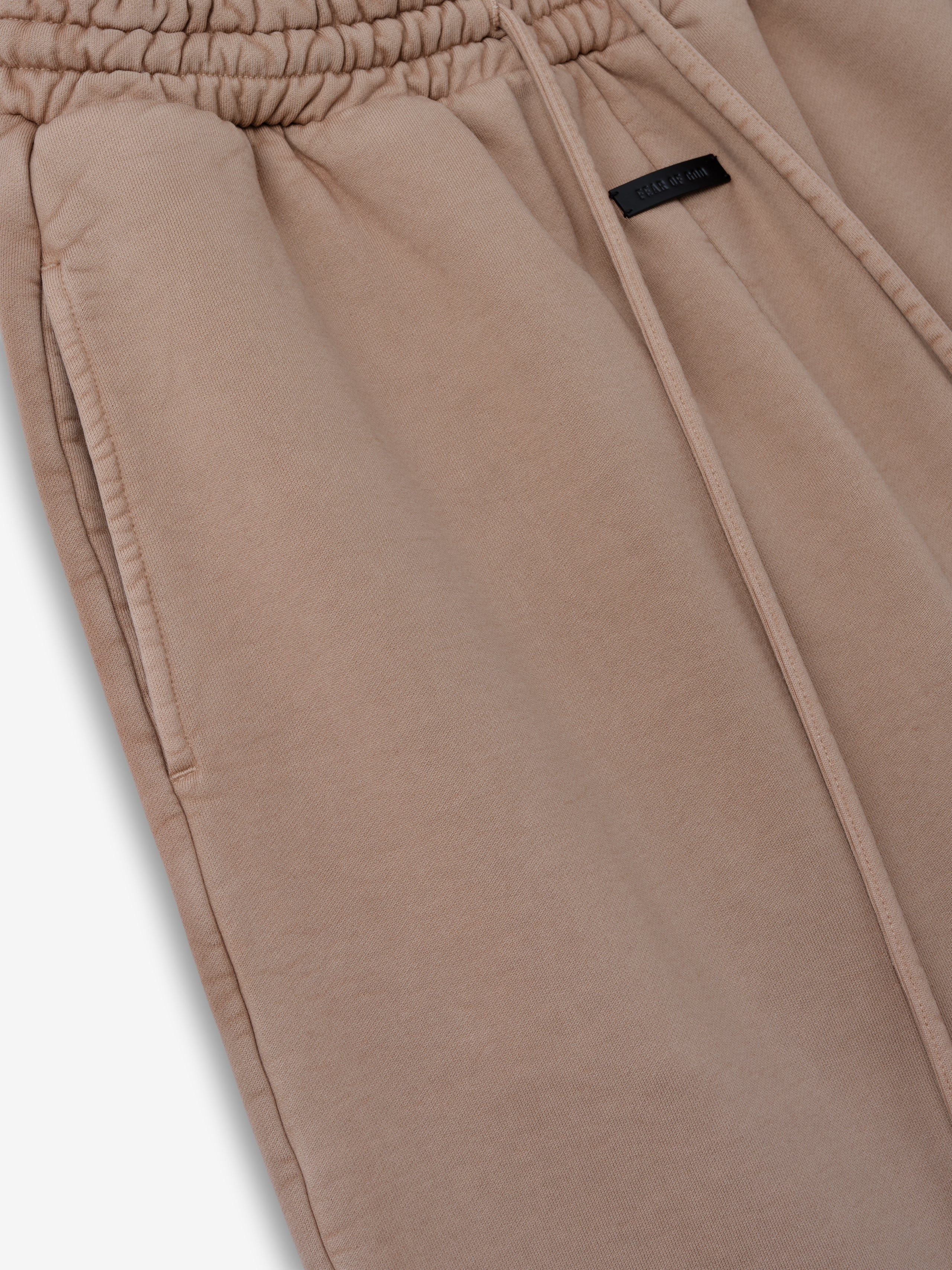 close-up of sunfaded beige heavyweight cotton fleece sweatpant with elastic waistband and side seam pocket