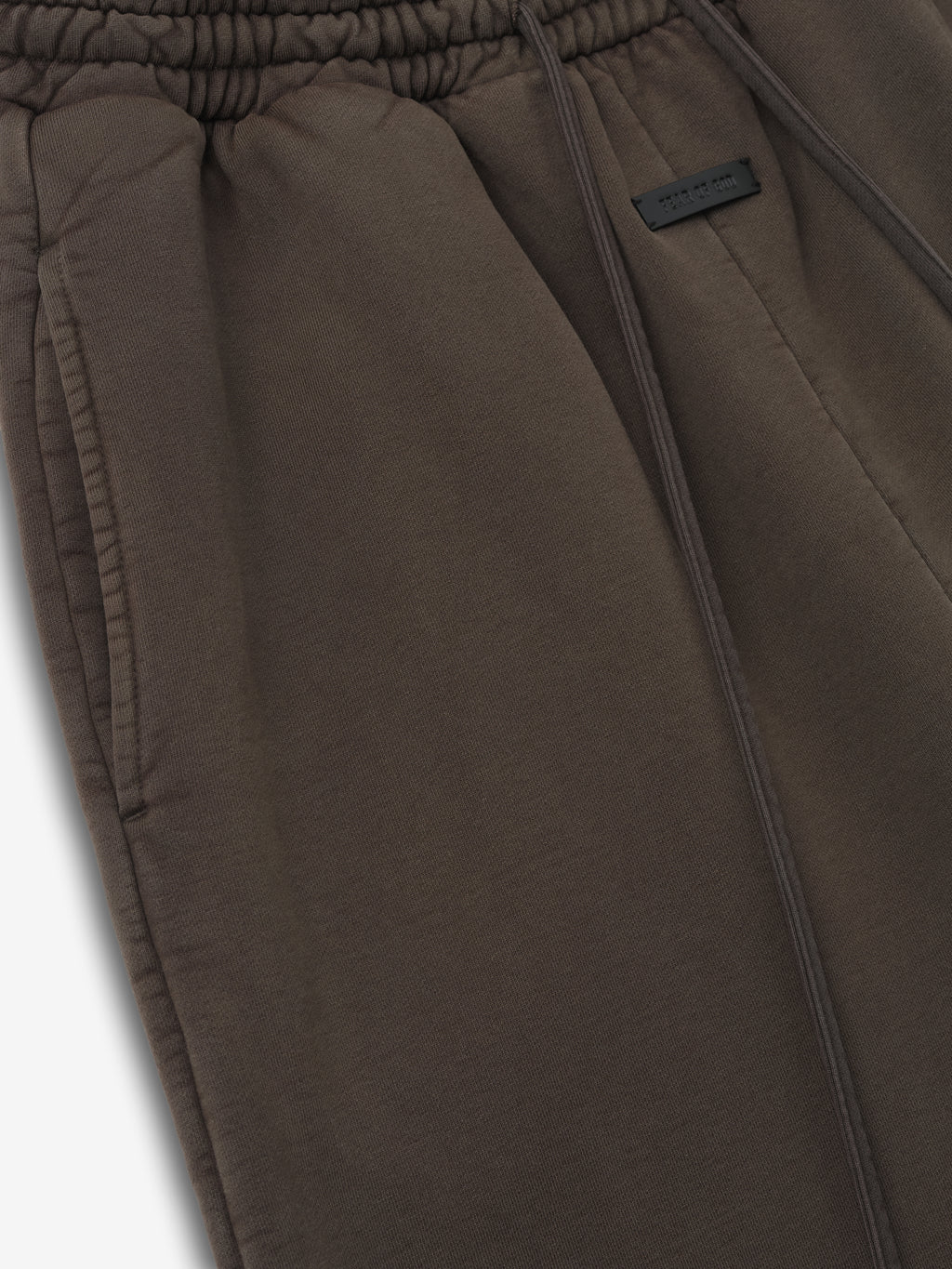 close-up of sunfaded dark taupe cotton fleece sweatpants with elastic waistband and front side pocket detailing