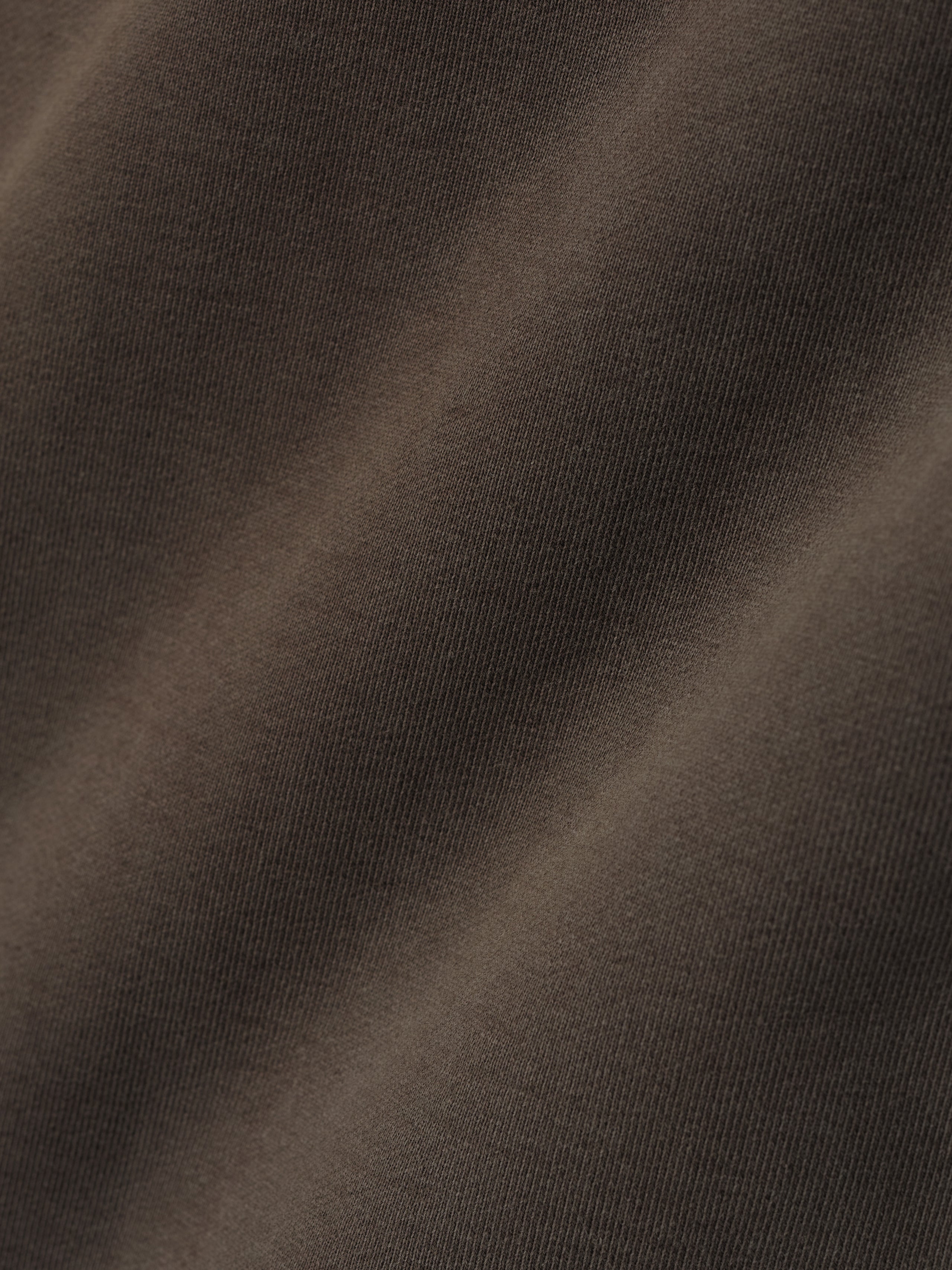 close-up of heavyweight cotton fleece fabric in sunfaded dark brown showing soft texture and vintage wash effect