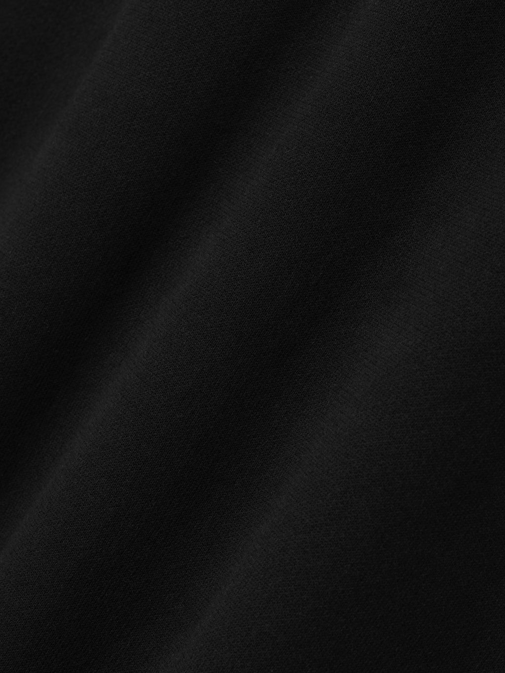 close-up of smooth black compact cotton-nylon double knit fabric with subtle texture and matte finish