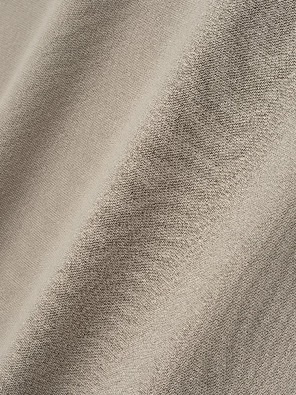 close-up of light beige merino Milano stitch fabric with smooth texture and fine-knit surface in soft natural color