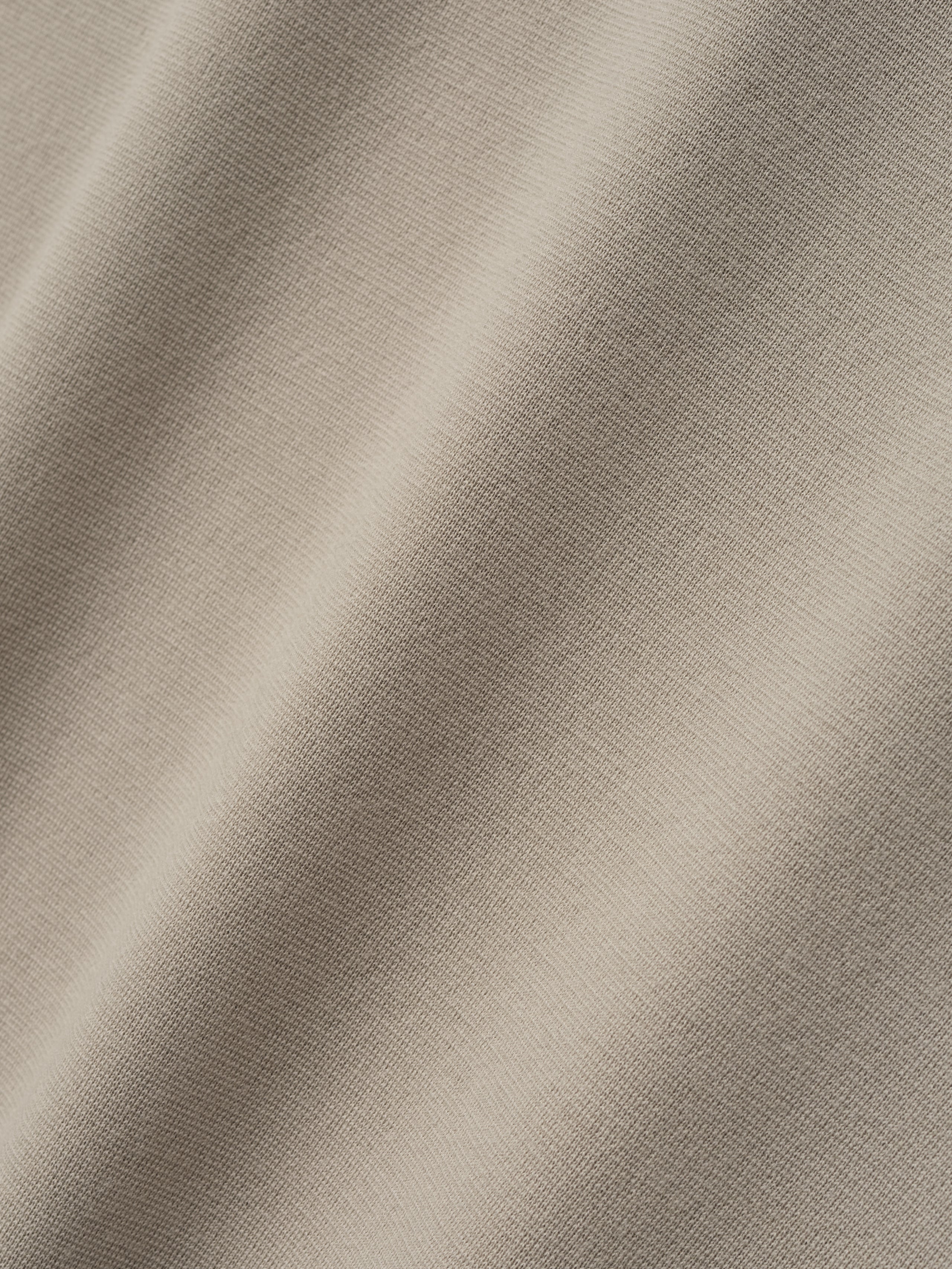 close-up of light beige merino Milano stitch fabric with smooth texture and fine-knit surface in soft natural color