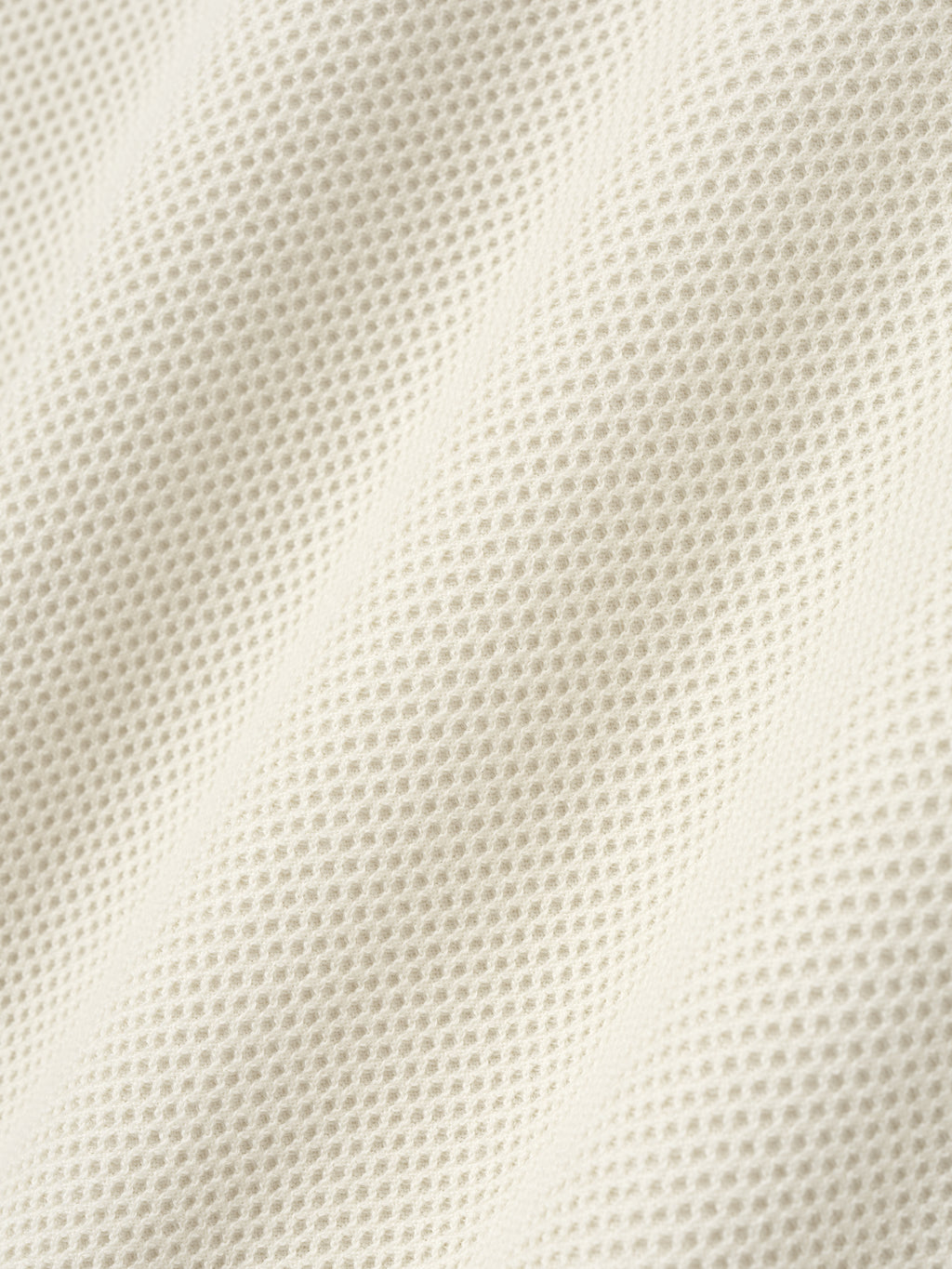 close-up texture of off-white double-knit sport mesh wool-cotton fabric with fine mesh stitch pattern