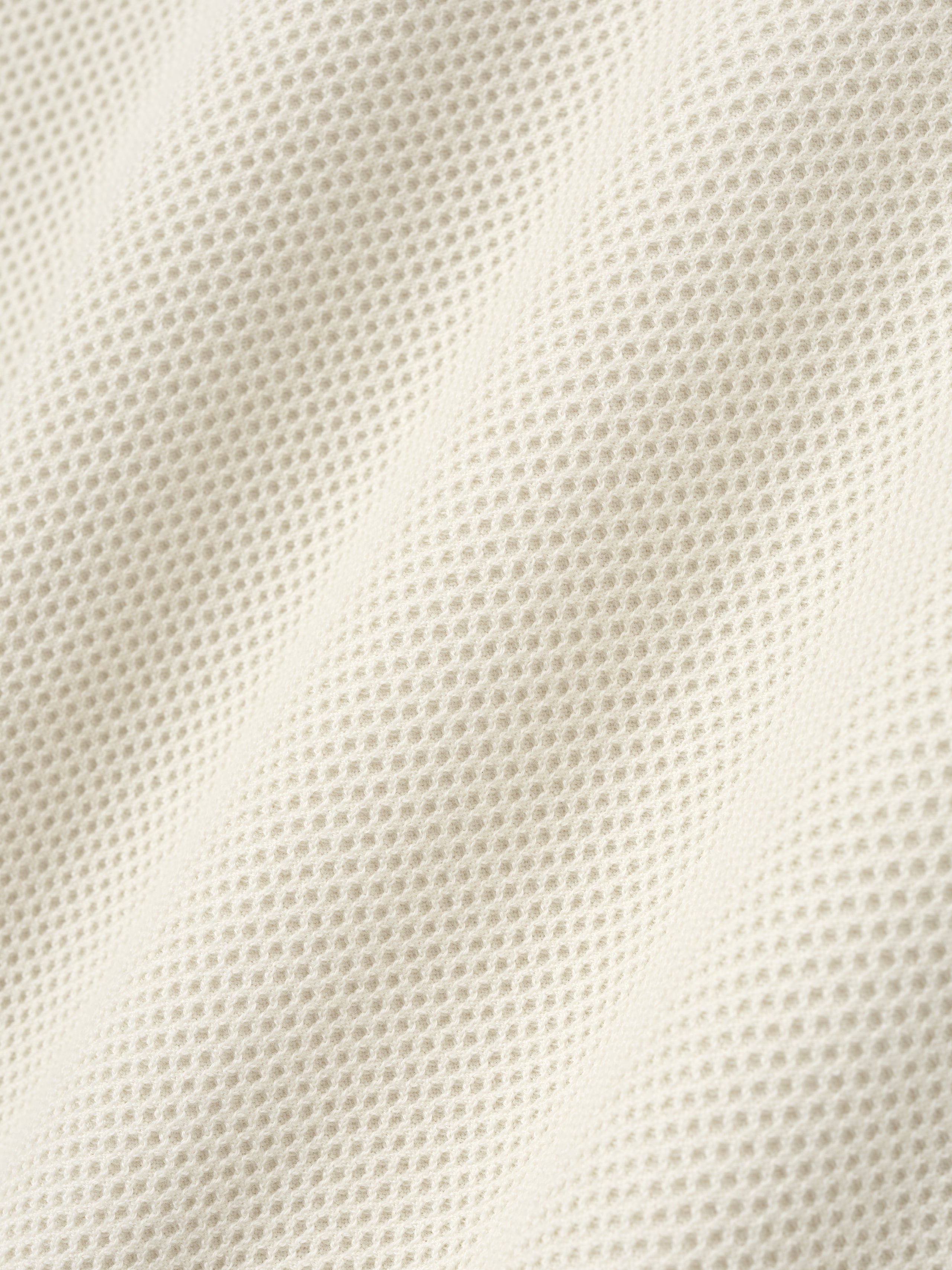 close-up texture of off-white double-knit sport mesh wool-cotton fabric with fine mesh stitch pattern