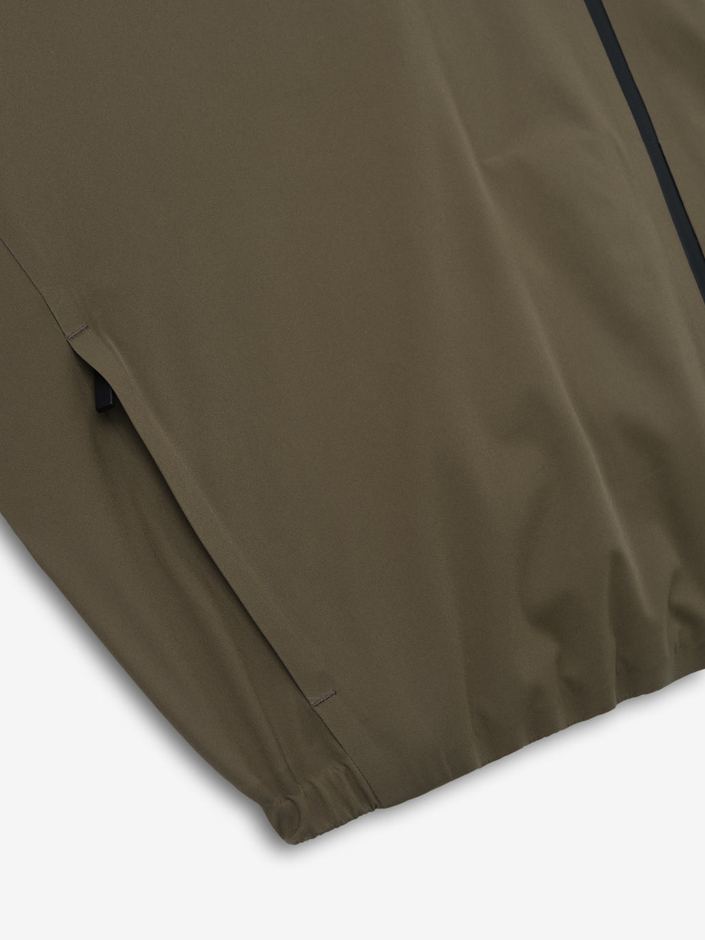 close-up of olive bonded nylon fabric with elasticated hem detail on tech track jacket sleeve