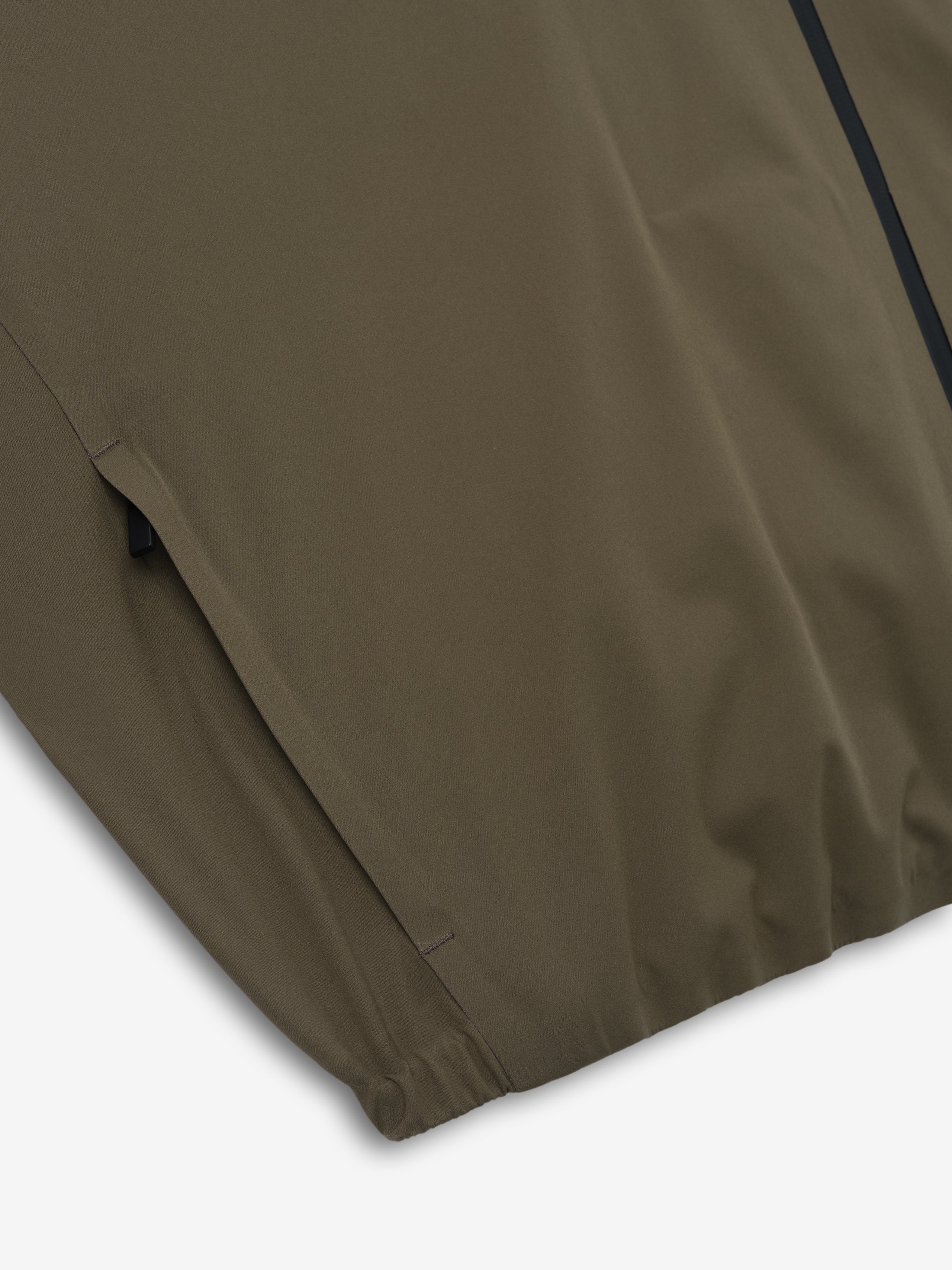 close-up of olive bonded nylon fabric with elasticated hem detail on tech track jacket sleeve