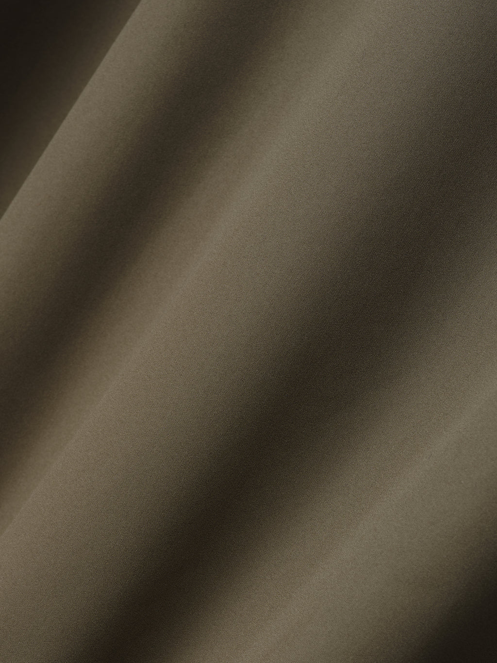 close-up of smooth olive bonded nylon microfibre fabric used in Italian tech track jacket