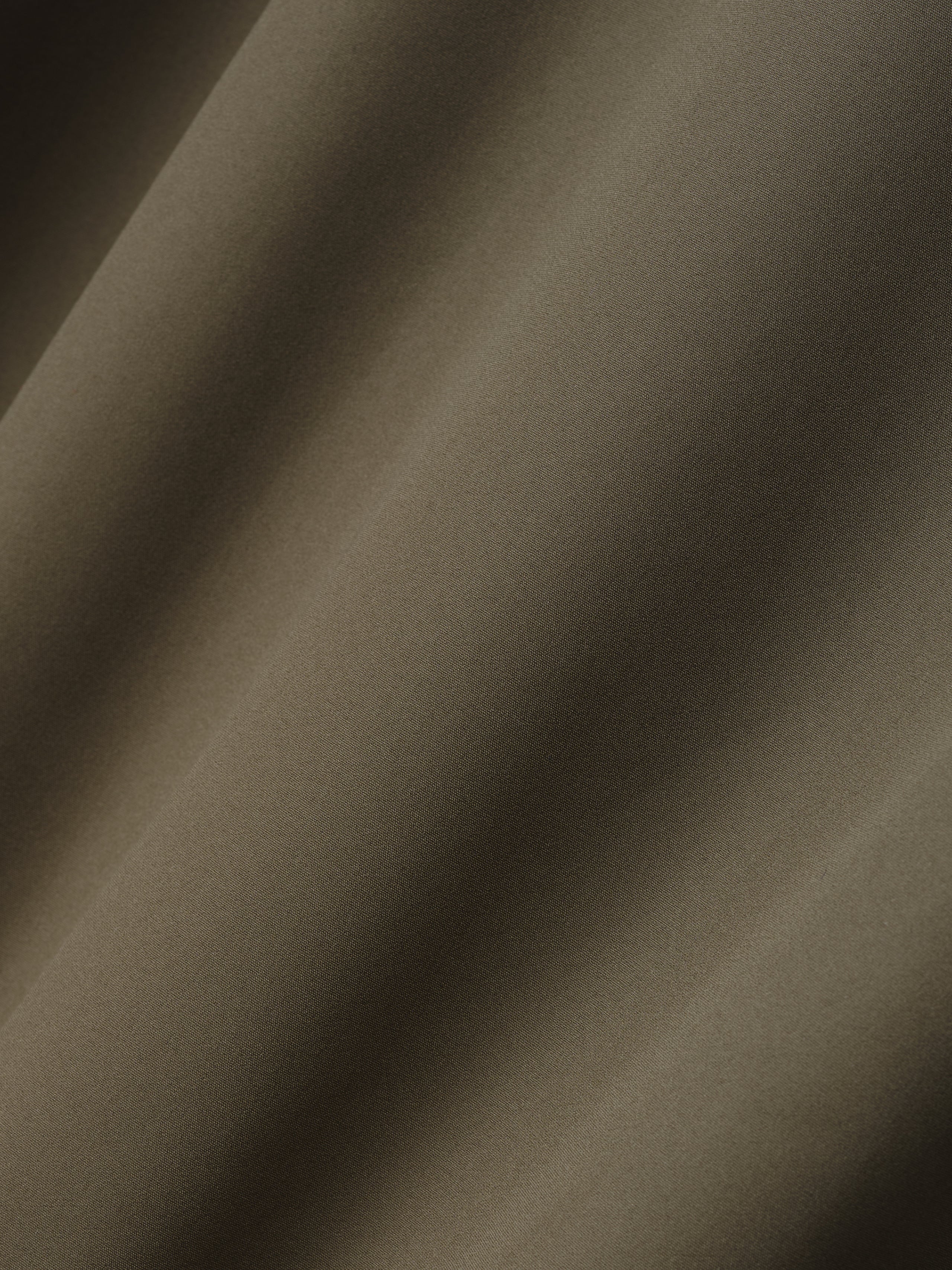 close-up of smooth olive bonded nylon microfibre fabric used in Italian tech track jacket