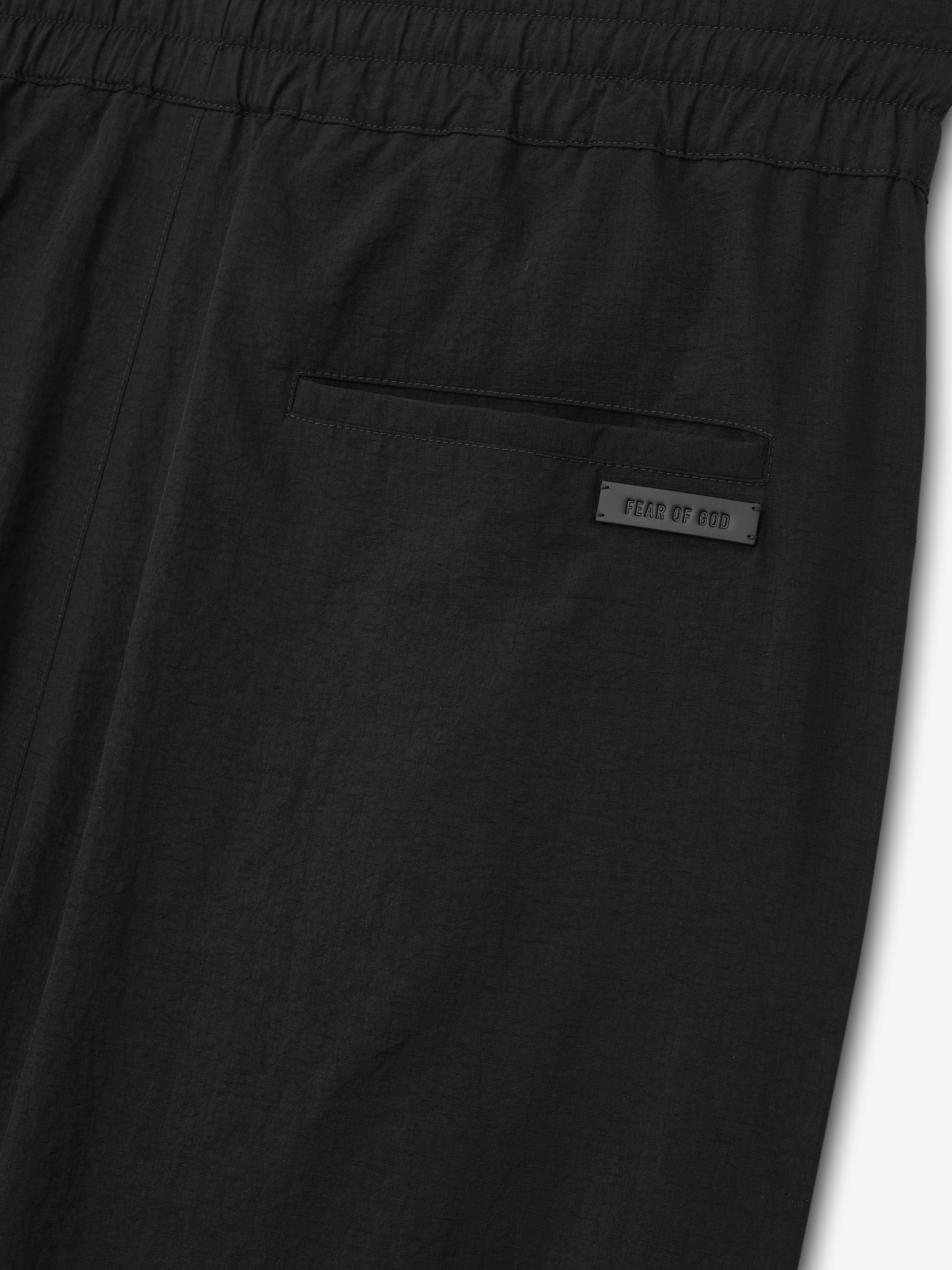 close-up of black recycled nylon ripstop fabric with elastic waistband and rear welt pocket featuring Fear of God label