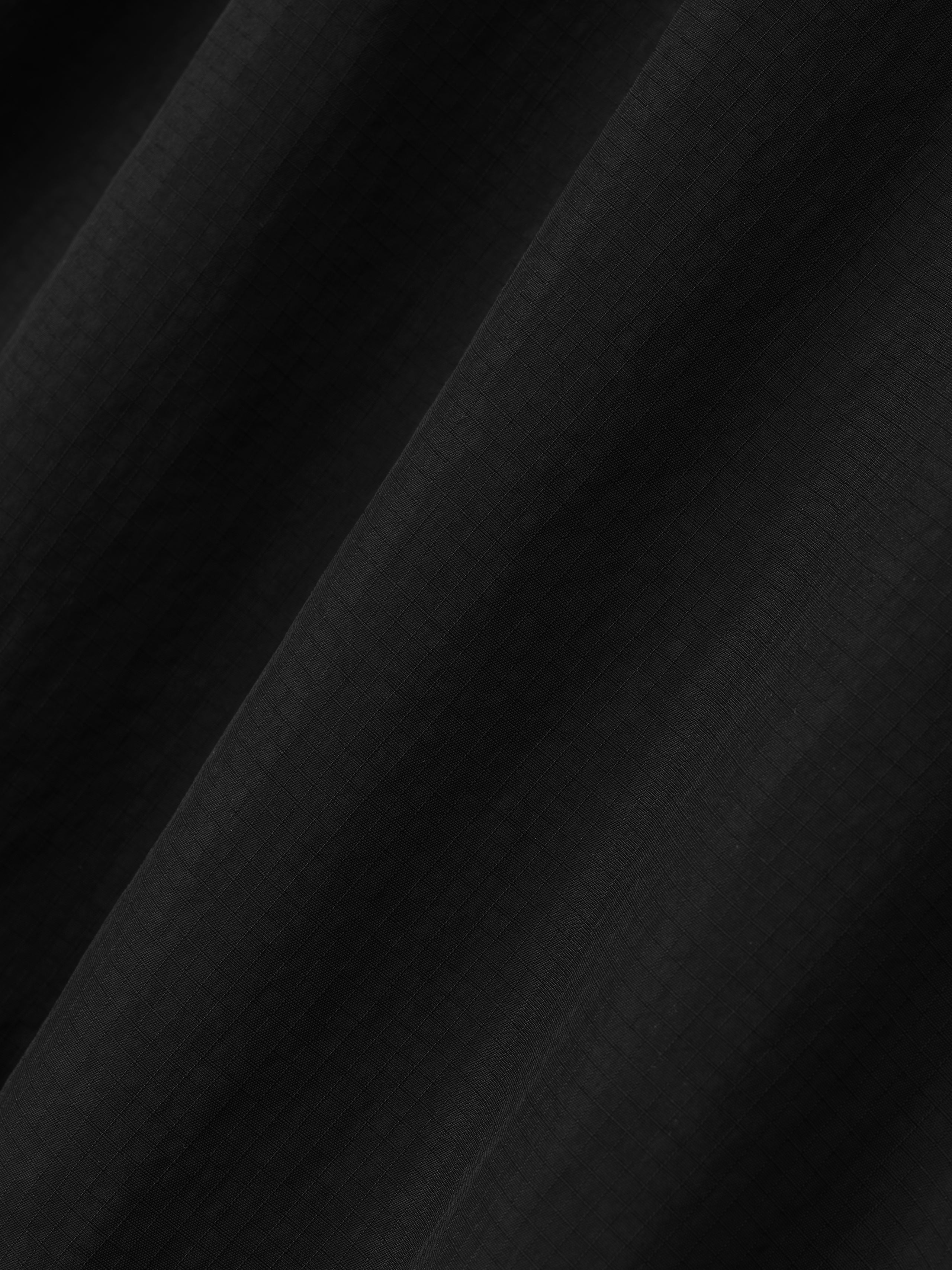 black recycled nylon ripstop fabric with subtle grid texture and soft matte finish in lightweight sport short material