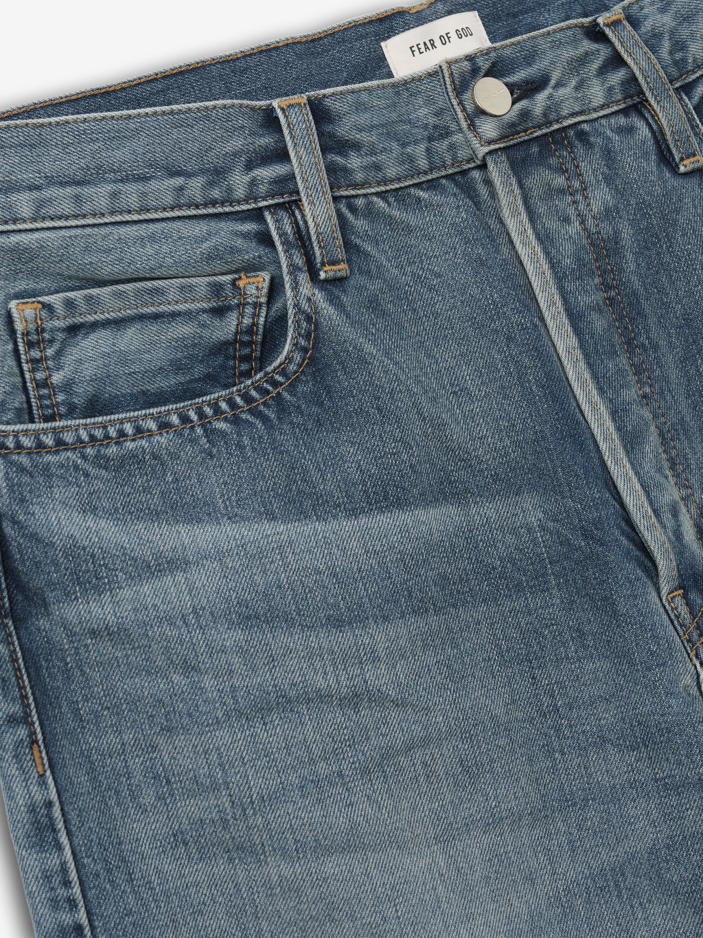 close-up of front waist and pocket details on classic blue indigo straight-leg Fear of God jeans