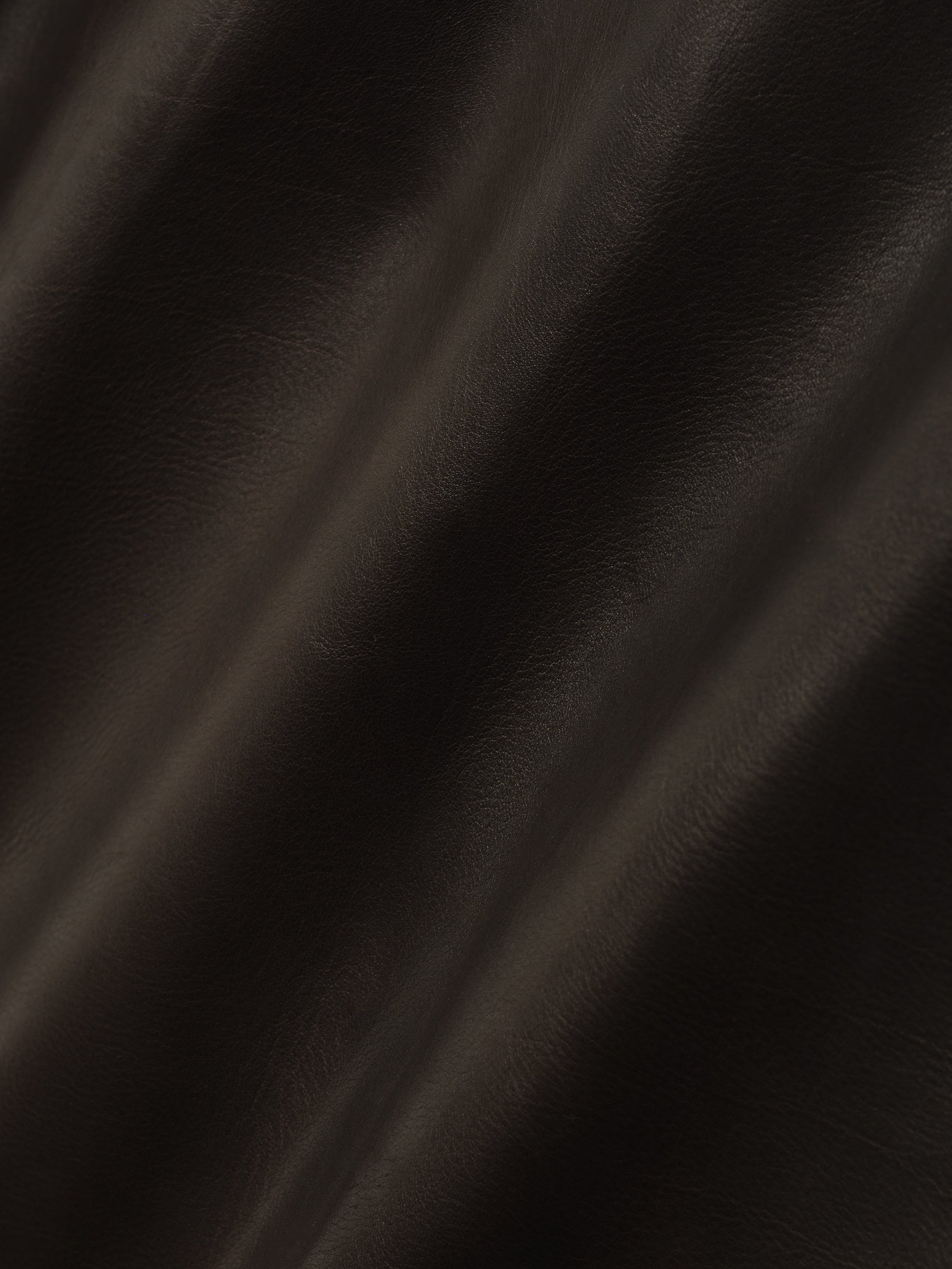 close-up of dark full grain calfskin leather showing smooth texture and natural soft grain pattern