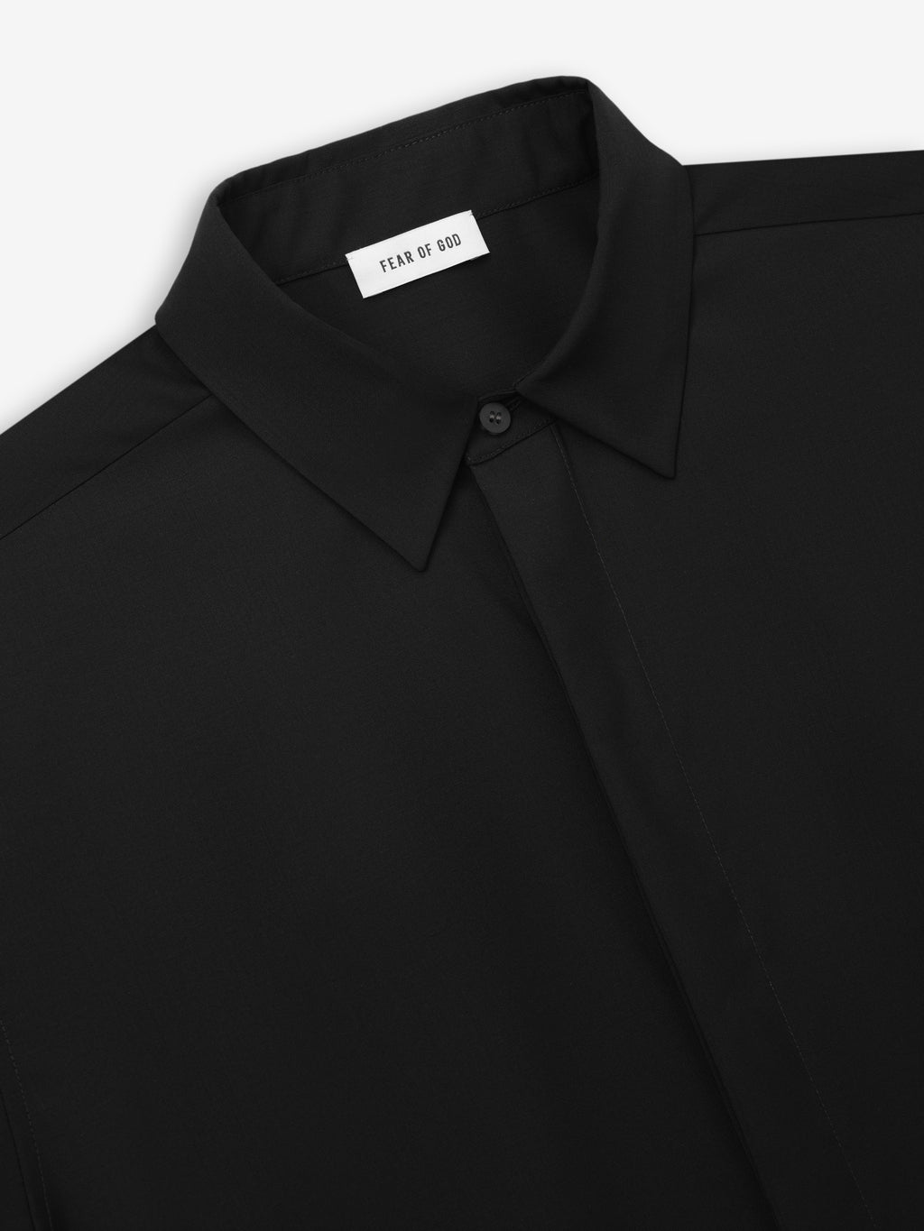Close-up of a black shirt collar with hidden buttons and a smooth matte finish on lightweight fabric