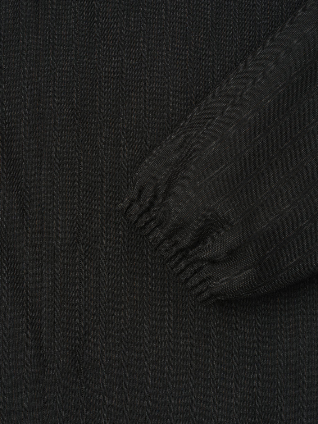 close-up of black yarn-dyed wool fabric with subtle stripes and elasticated cuff on sleeve