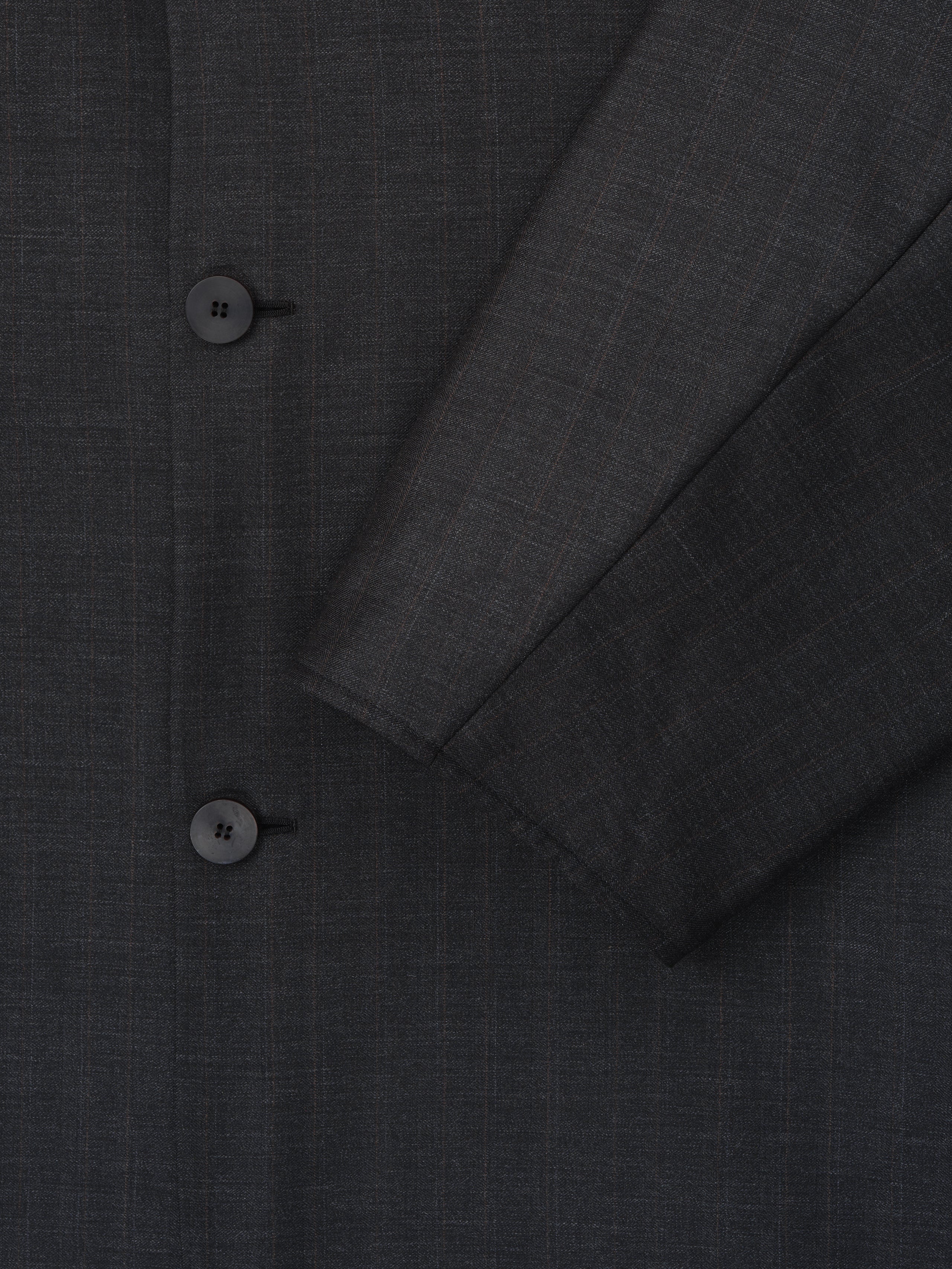 Close-up of dark gray jacket fabric with subtle check pattern and two black buttons on front panel