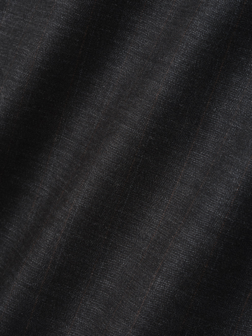 Close-up of black fabric with subtle herringbone pattern and faint vertical lines creating texture and depth