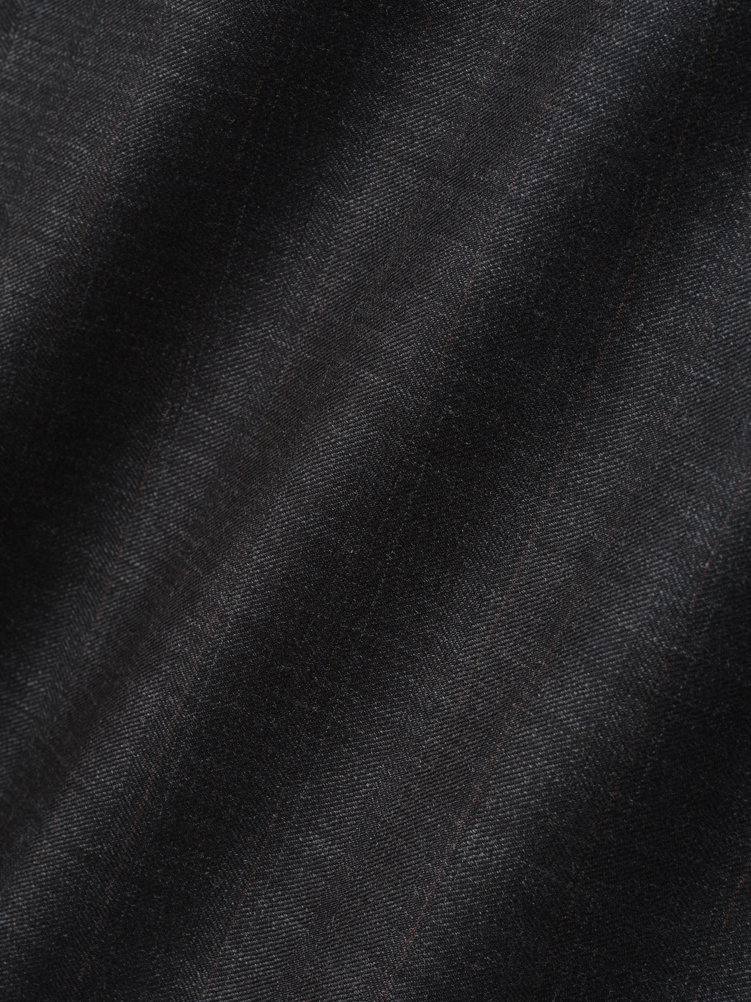 Close-up of black fabric with subtle herringbone pattern and faint vertical lines creating texture and depth