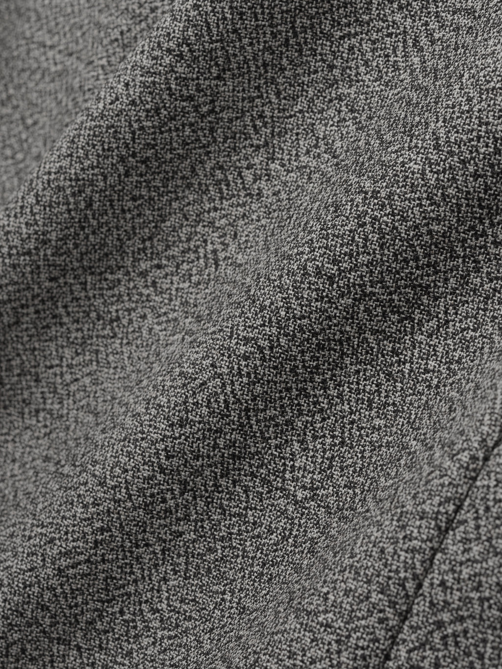 close-up of grey virgin wool mouliné fabric showing textured weave and soft drape of relaxed lapelless jacket