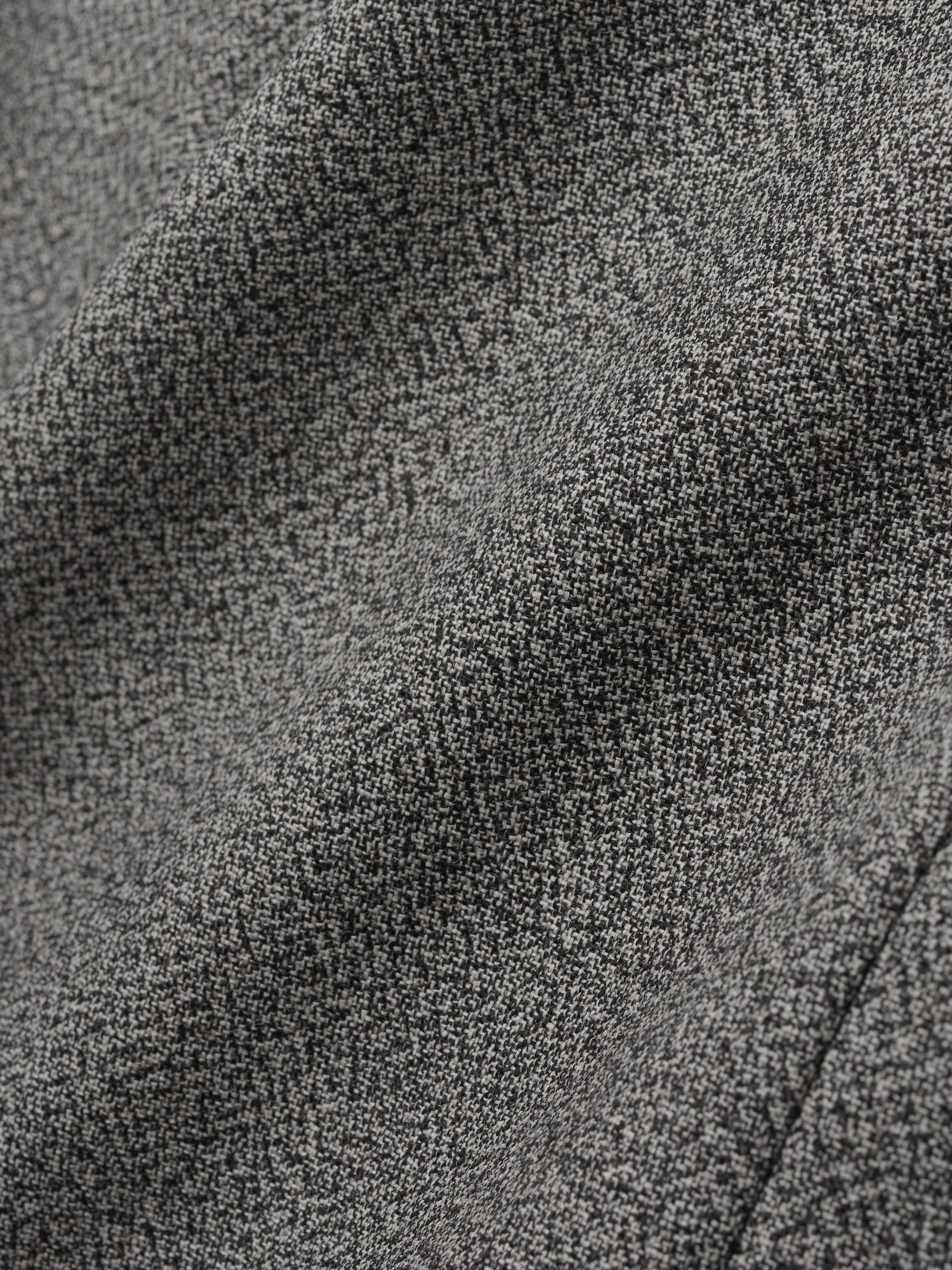 close-up of grey virgin wool mouliné fabric showing textured weave and soft drape of relaxed lapelless jacket