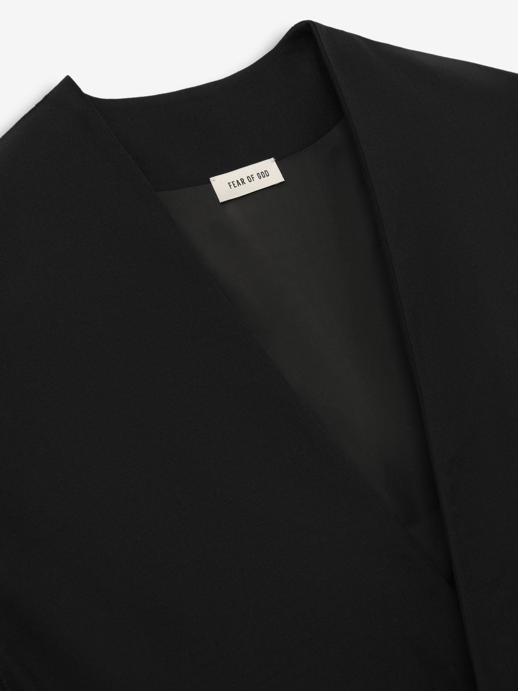 close-up of black collarless lightweight wool ripstop fabric and smooth Bemberg cupro lining inside cropped jacket