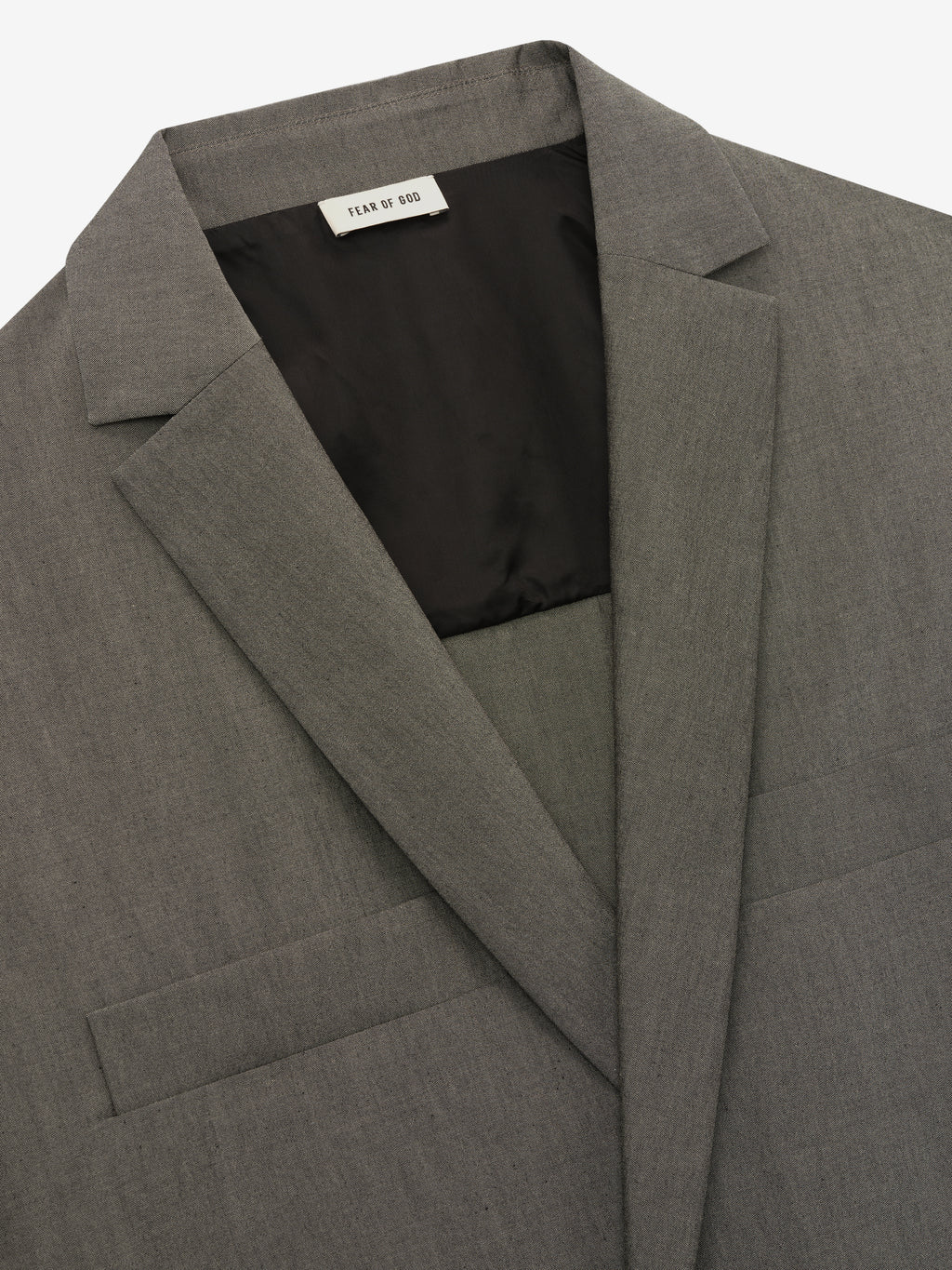close-up of grey cotton-wool oxford fabric on relaxed-fit shirt jacket with notched lapel and interior black lining