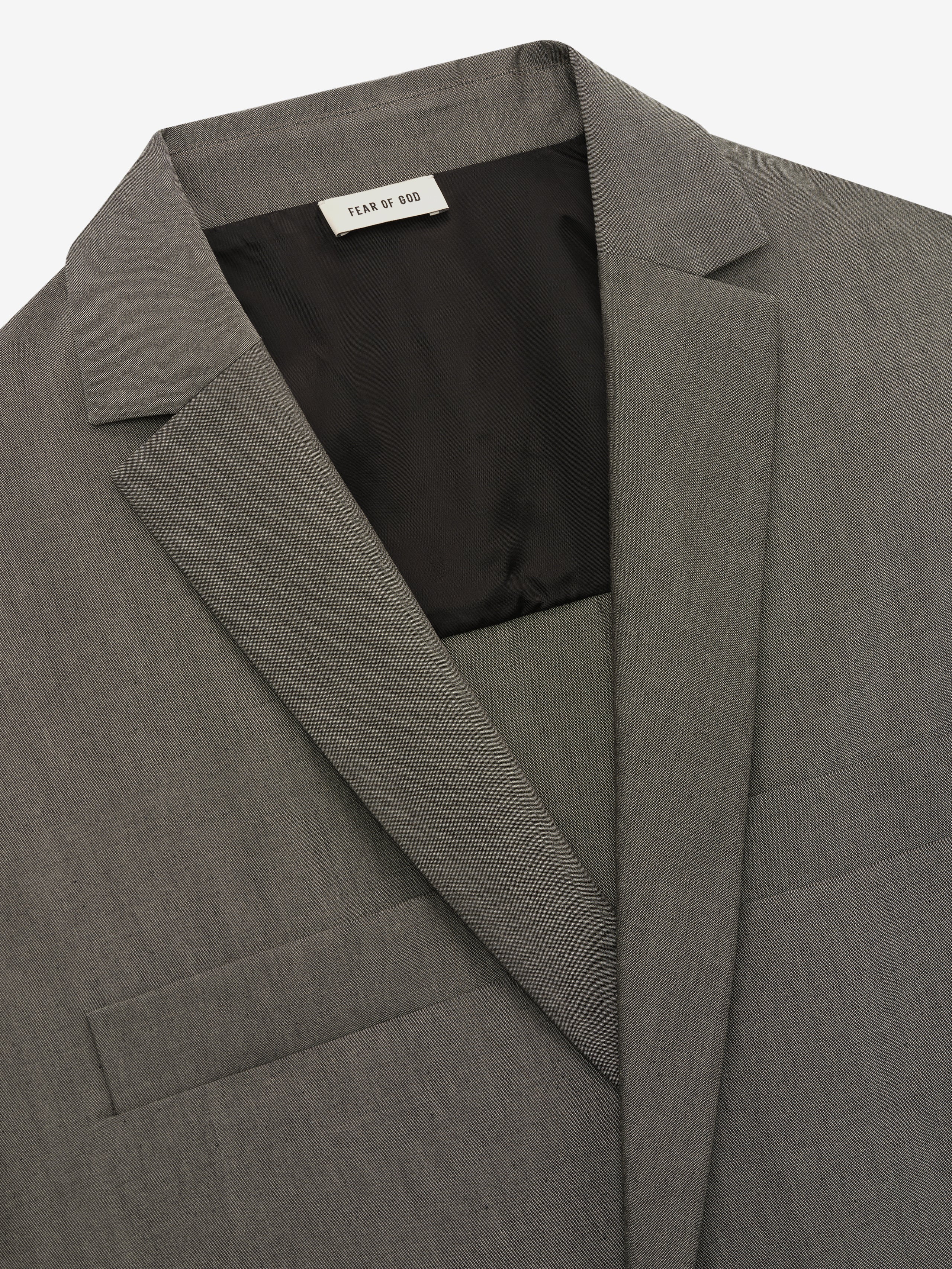 close-up of grey cotton-wool oxford fabric on relaxed-fit shirt jacket with notched lapel and interior black lining