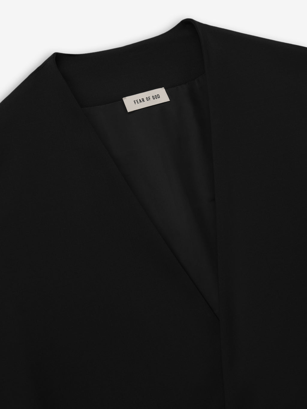 close-up of black lapelless jacket neckline with smooth lightweight wool canvas and Fear of God label inside collar
