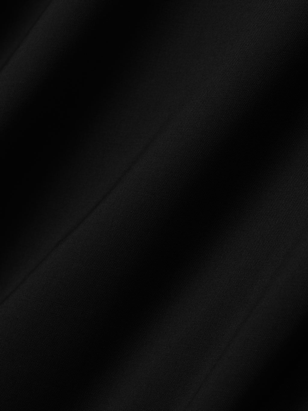 close-up of smooth lightweight black wool canvas fabric with subtle texture and soft drape
